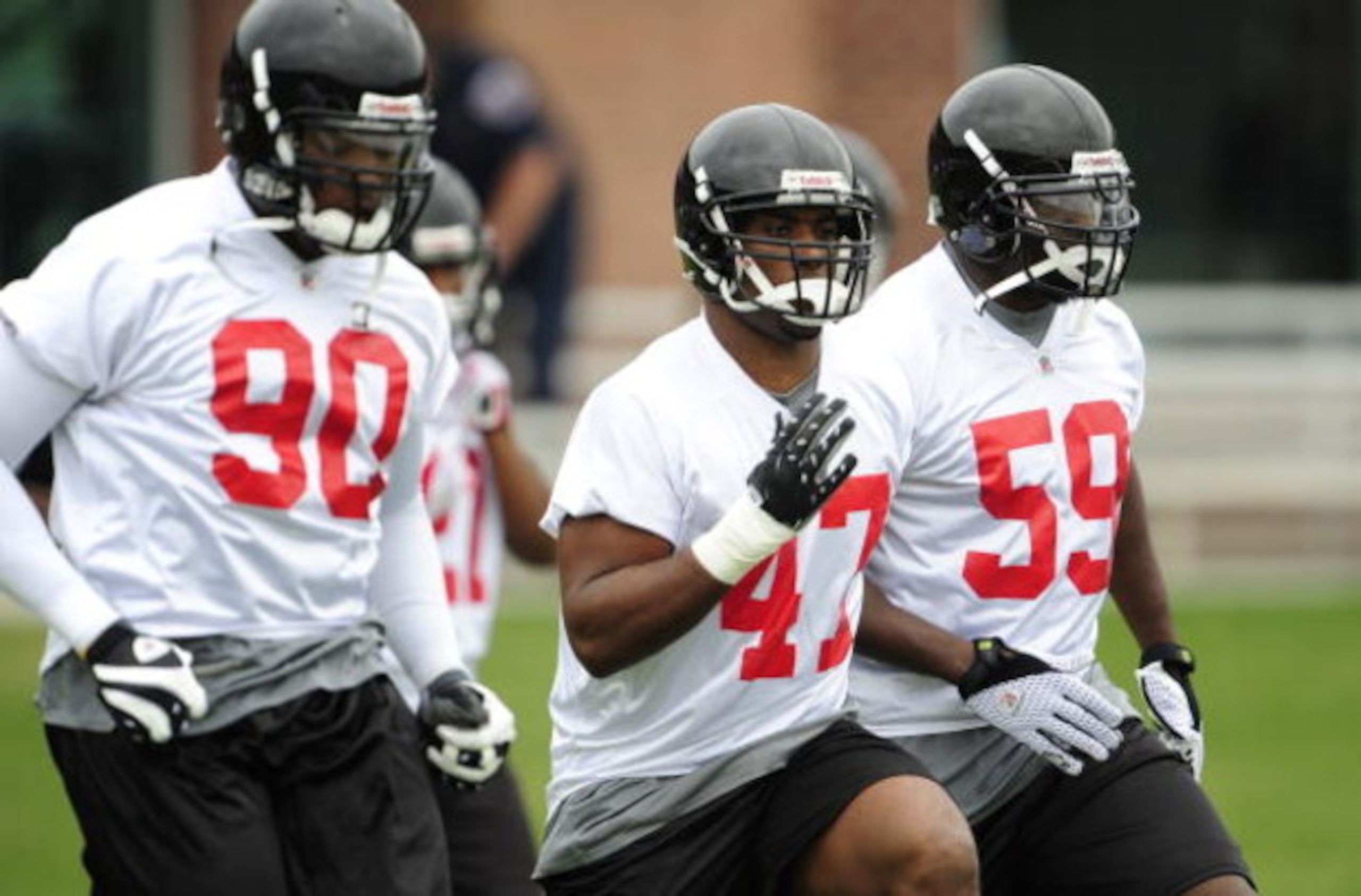 FLOWERY BRANCH, GA - MAY 9: Defensive end Lawrence Sidbury #90, linebacker Derek Nicholson #47 and linebacker Spencer Adkins #59 of the Atlanta Falcons warm up prior to minicamp at the Falcons Complex on May 9, 2009 in Flowery Branch, Georgia.  (Photo by 