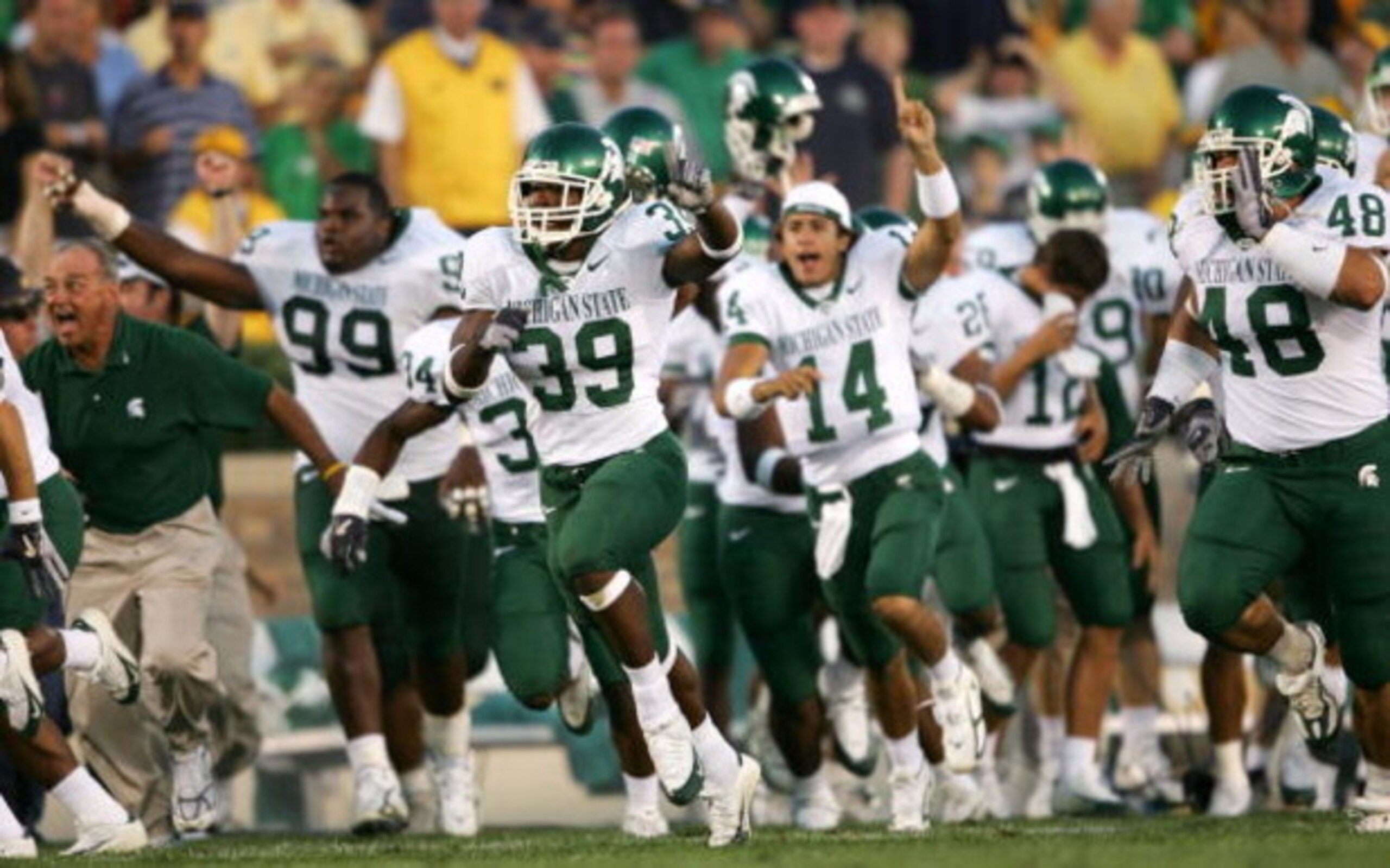 SOUTH BEND, IN - SEPTEMBER 17:  Running back Javon Ringer #39 of the Michigan State Spartans leads the bench onto the field in celebration after defeating the Notre Dame Fighting Irish in overtime on September 17, 2005 at Notre Dame Stadium in South Bend,