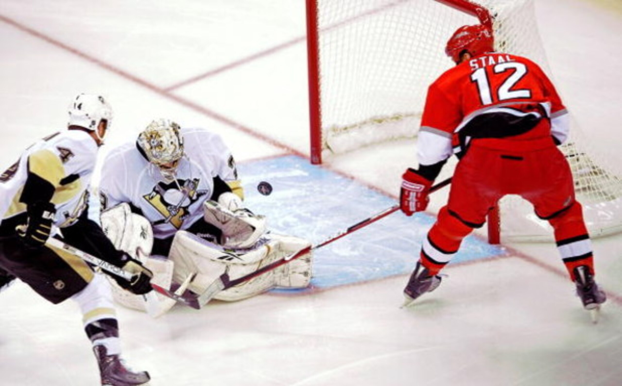 RALEIGH, NC - MAY 23:  Rob Scuderi #4 defends as goaltender Marc-Andre Fleury #29 of the Pittsburgh Penguins saves a shot on goal by Eric Staal #12 of the Carolina Hurricanes during Game Three of the Eastern Conference Championship Round of the 2009 Stanl