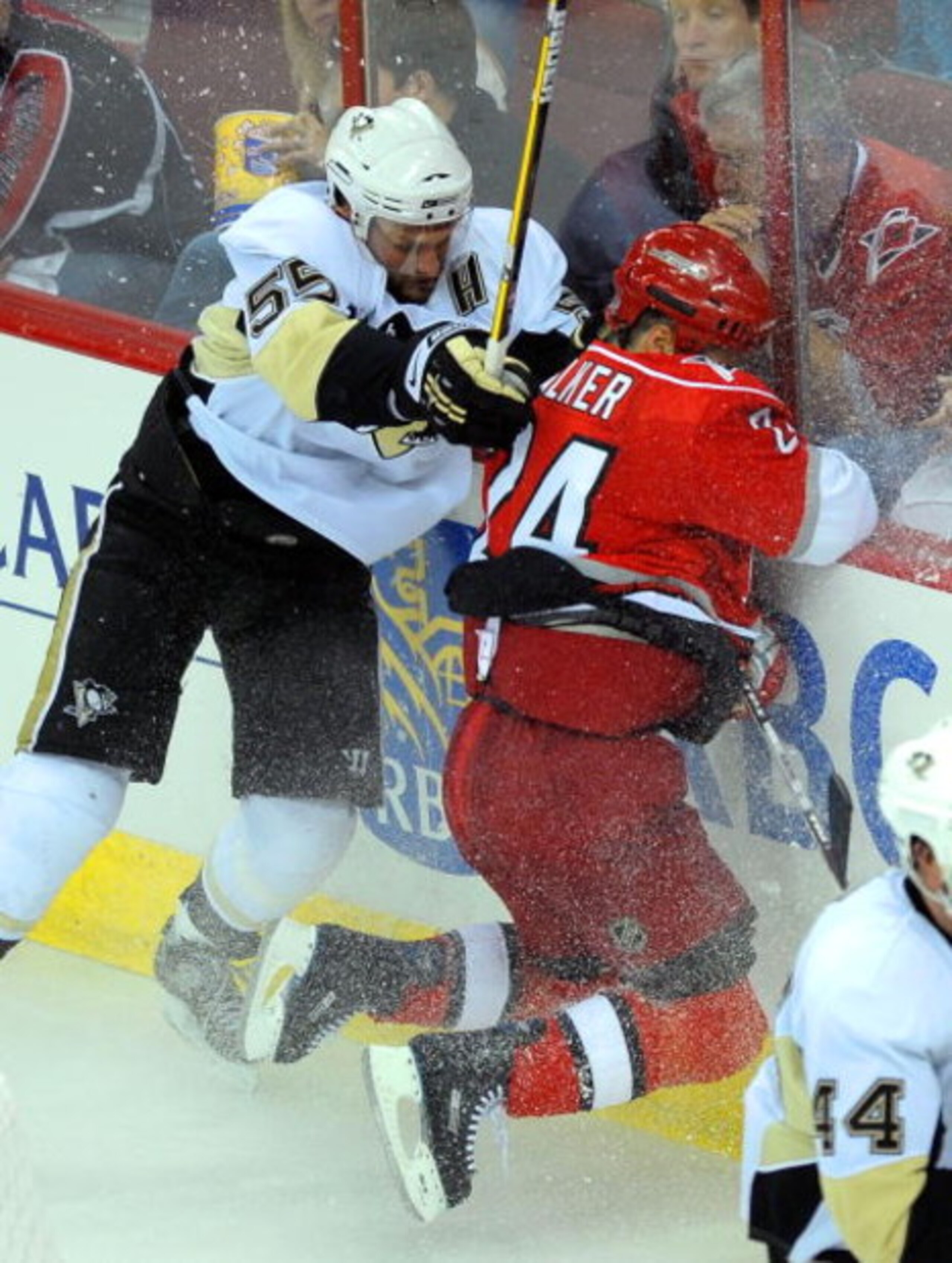 RALEIGH, NC - MAY 23:  Sergei Gonchar #55 of the Pittsburgh Penguins checks Scott Walker #24 of the Carolina Hurricanes into the boards during Game Three of the Eastern Conference Championship Round of the 2009 Stanley Cup Playoffs at RBC Center on May 23