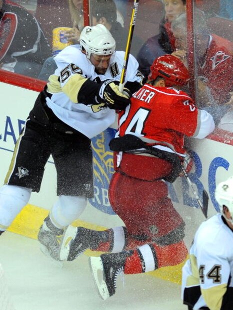 RALEIGH, NC - MAY 23:  Sergei Gonchar #55 of the Pittsburgh Penguins checks Scott Walker #24 of the Carolina Hurricanes into the boards during Game Three of the Eastern Conference Championship Round of the 2009 Stanley Cup Playoffs at RBC Center on May 23