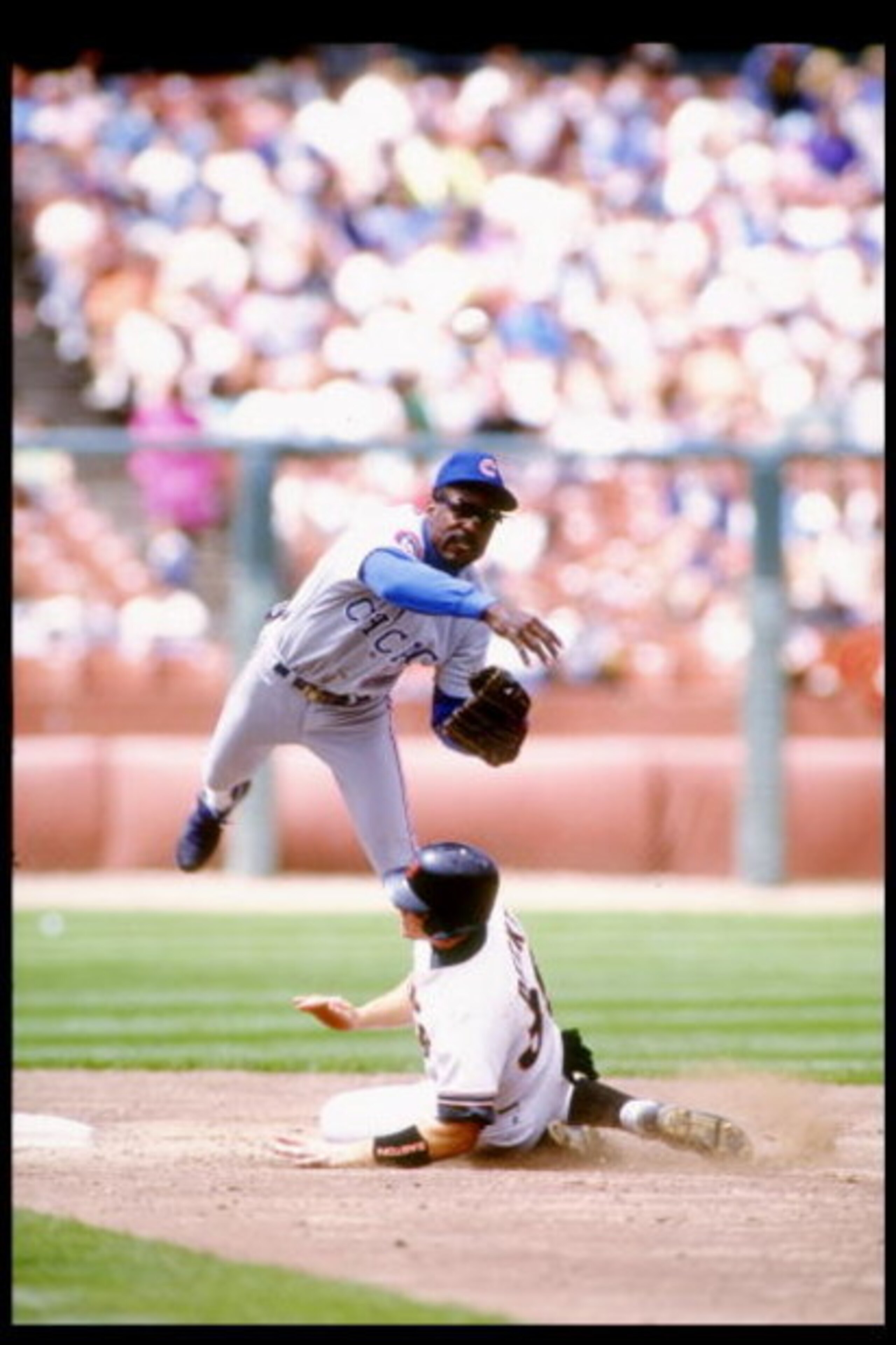Shortstop Shawon Dunston of the Chicago Cubs tries to tag out Steve Decker of the San Francisco Giants at Candlestick Park in San Francisco, California.