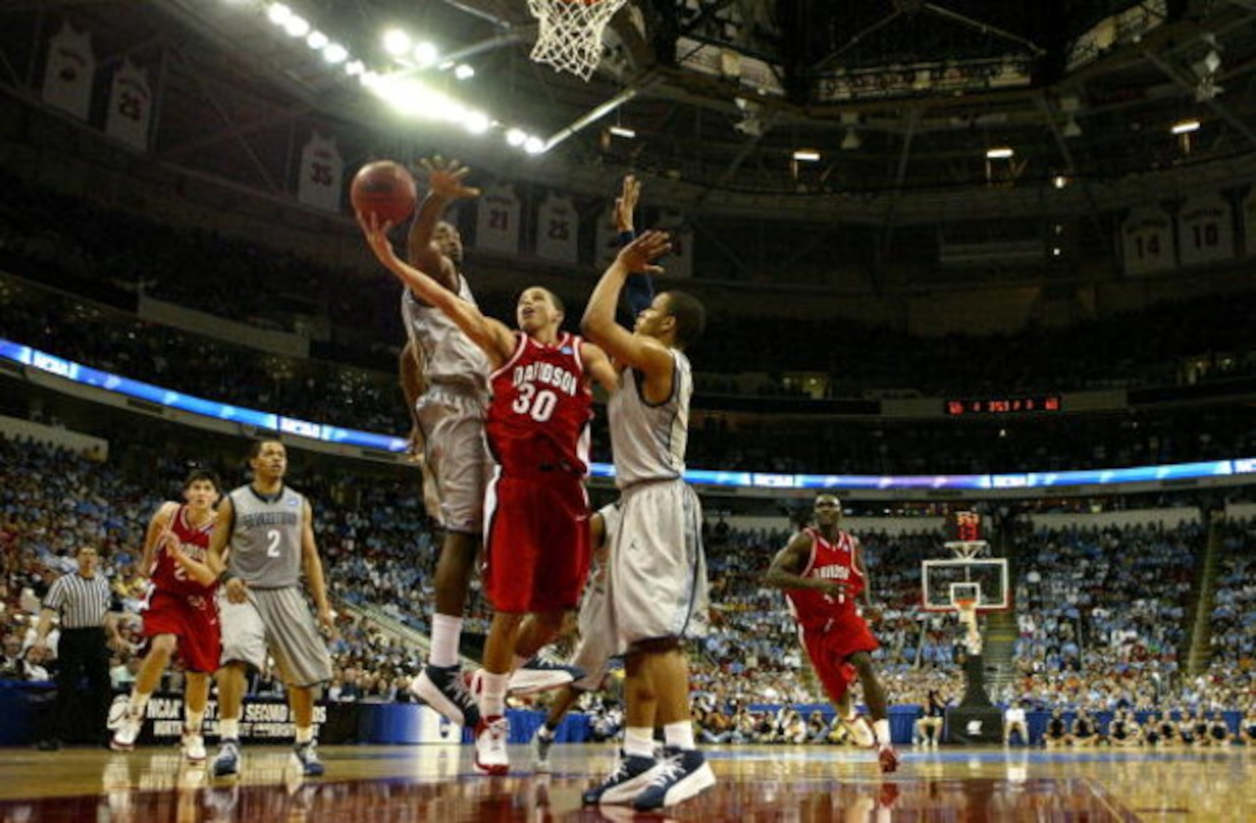 RALEIGH, NC - MARCH 23:  Stephen Curry #30 of the Davidson Wildcats goes up for a basket between teammates DeJuan Summers #3 and Chris Wright #4 of the Georgetown Hoyas during the second round of the 2008 NCAA Men's Basketball Tournament Midwest Regionals