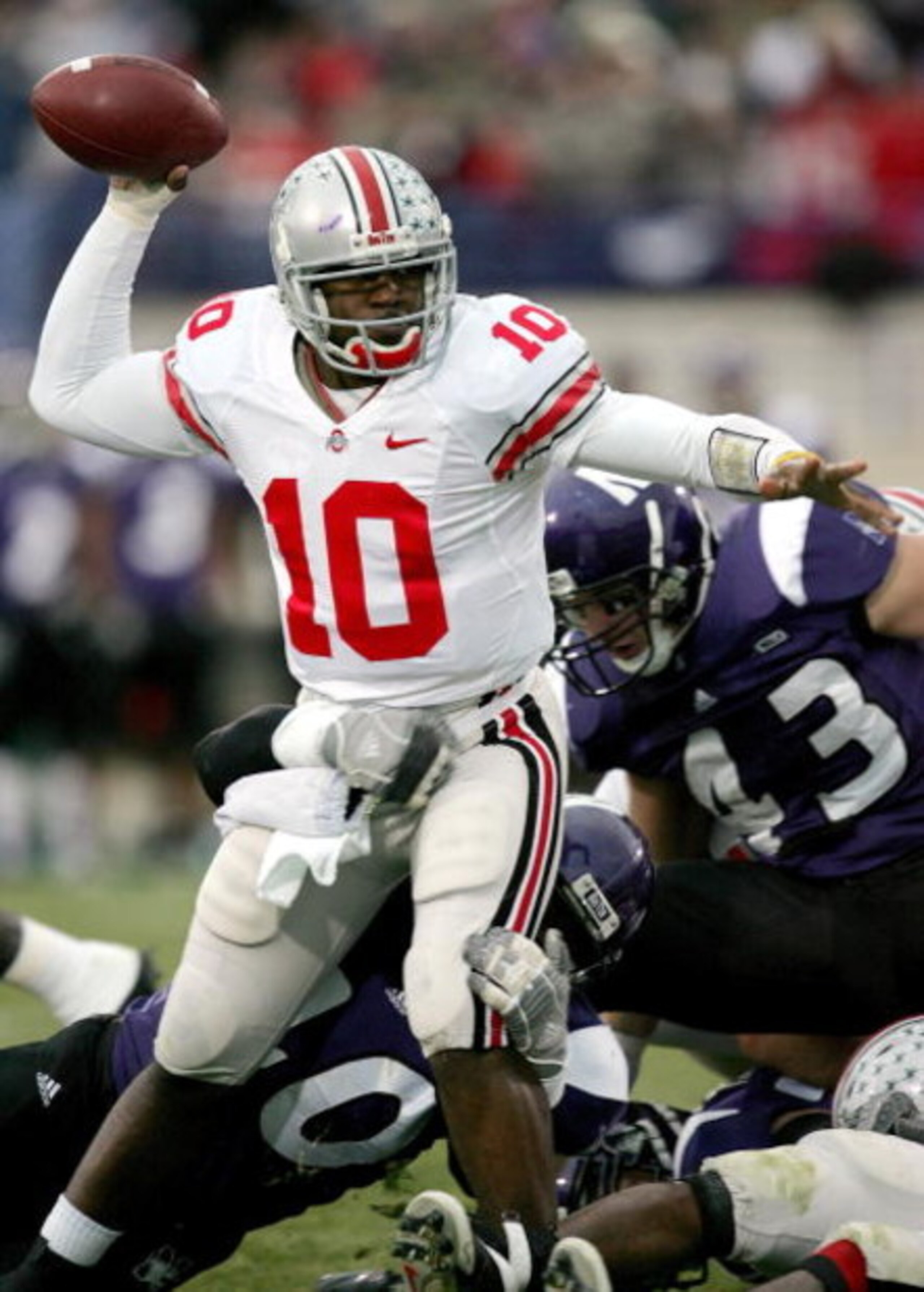 EVANSTON, IL - NOVEMBER 11:  Troy Smith #10 of the Ohio State Buckeyes looks to pass while in the grasp of Eddie Simpson #40 of the Northwestern Wildcats on November 11, 2006 at Ryan Field in Evanston, Illinois.  (Photo by Jonathan Daniel/Getty Images)