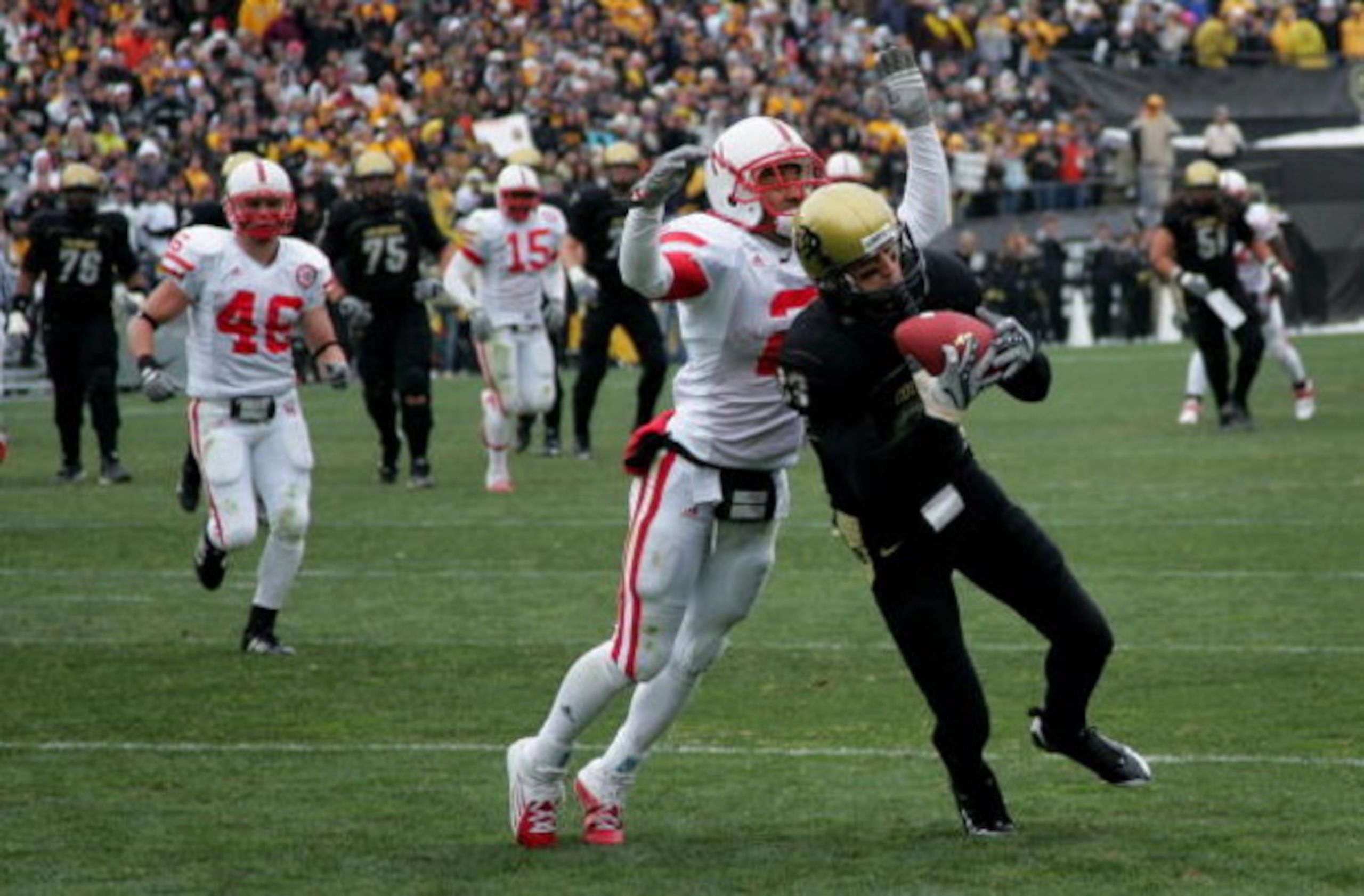 BOULDER, CO - NOVEMBER 23:  Dusty Sprague #83 of the Colorado Buffaloes catches a pass for 22 yards to the Nebraska one yard line and is tackled by Cortney Grixby #2 of the Nebraska Cornhuskers in the third quarter during Big 12 College Football action at