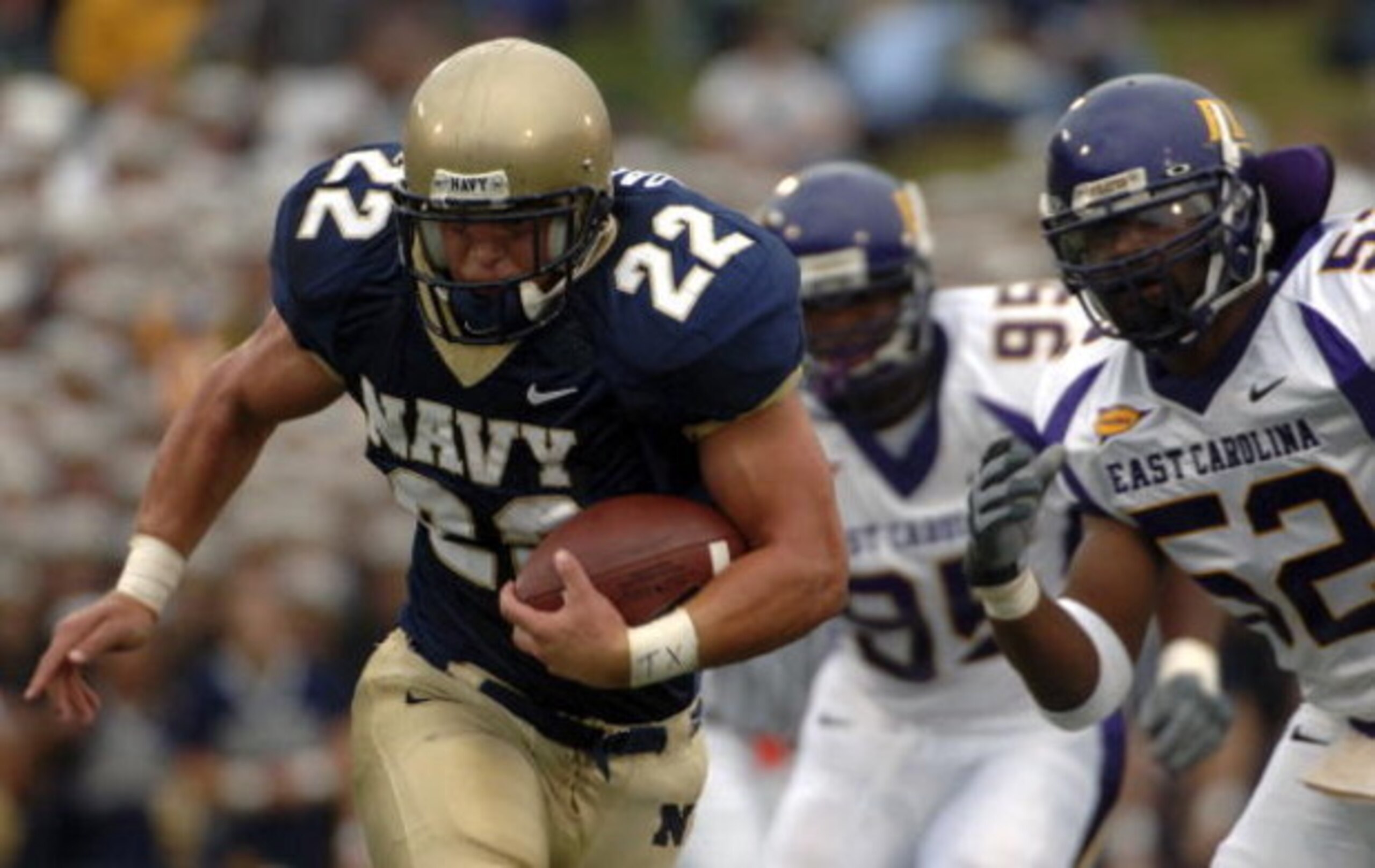 ANNAPOLIS, MD - SEPTEMBER 02:  In this handout photo Adam Ballard #22 of the Navy Midshipman is chased by Jarrett Wiggins #52 and C.J. Wilson #95 of the East Carolina Pirates in the first half of play at Navy-Marine Corps Memorial Stadium September 02, 20
