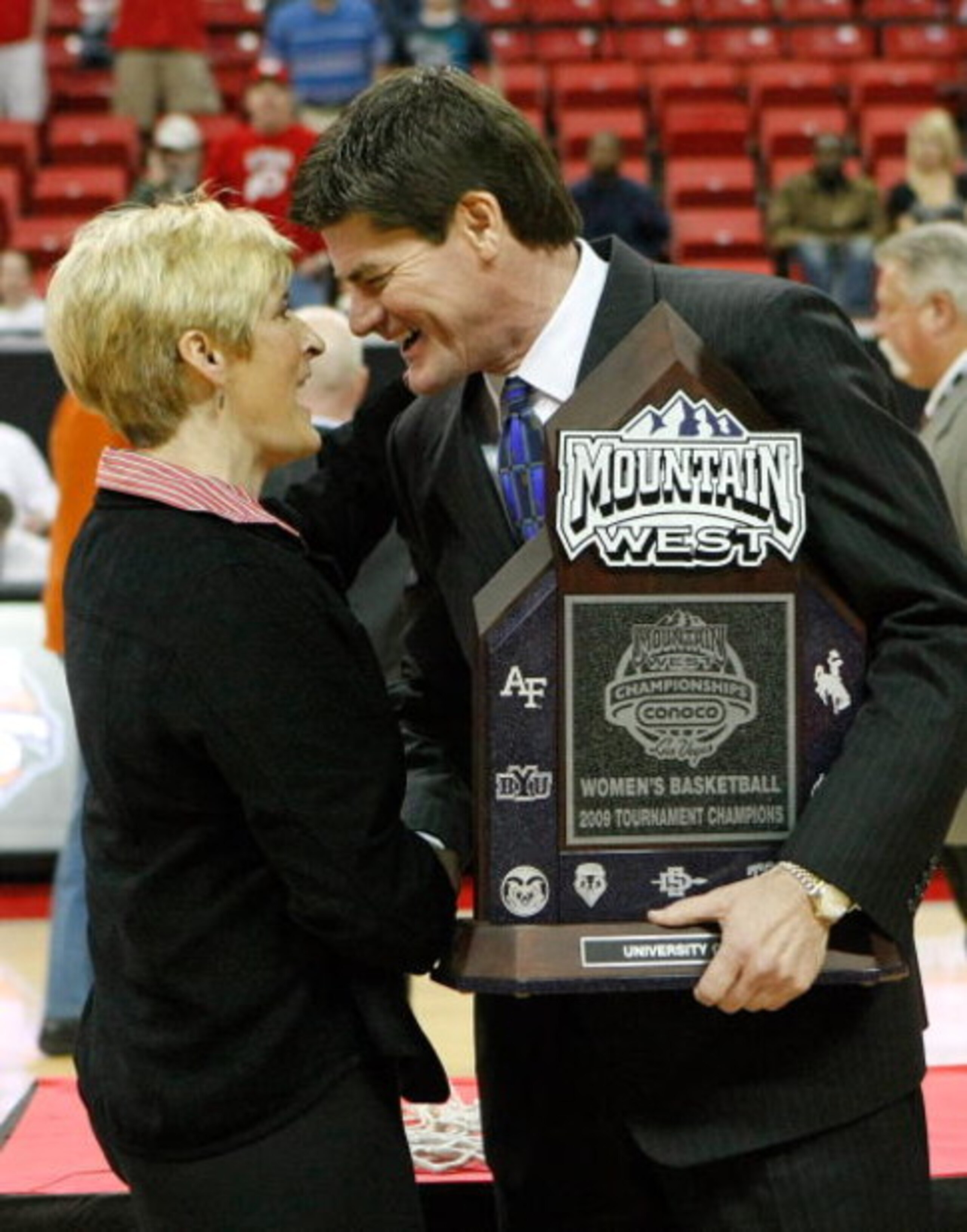 LAS VEGAS - MARCH 14:  Mountain West Conference commissioner Craig Thompson (R) presents the trophy to head coach Elaine Elliott of the Utah Utes after they defeated the San Diego State Aztecs 63-58 during the championship game of the Conoco Mountain West