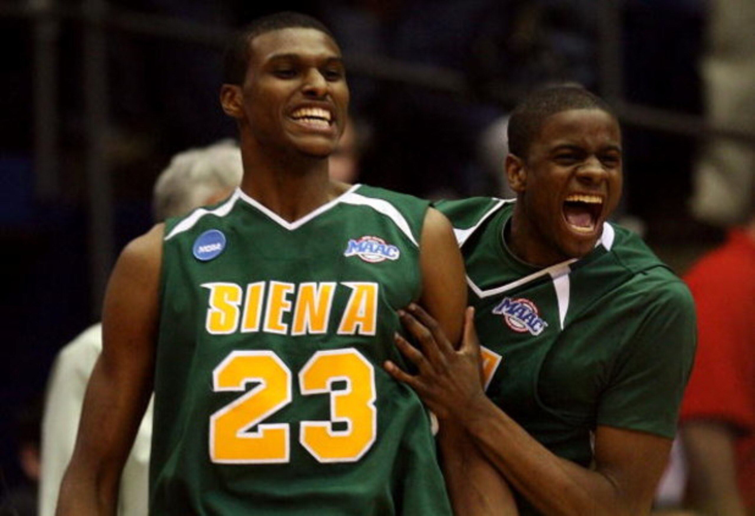 DAYTON, OH - MARCH 20:  Edwin Ubiles #23 and Clarence Jackson #13 of the Siena Saints celebrate on the court after defeating the Ohio State Buckeyes in overtime during the first round of the NCAA Division I Men's Basketball Tournament at the University of