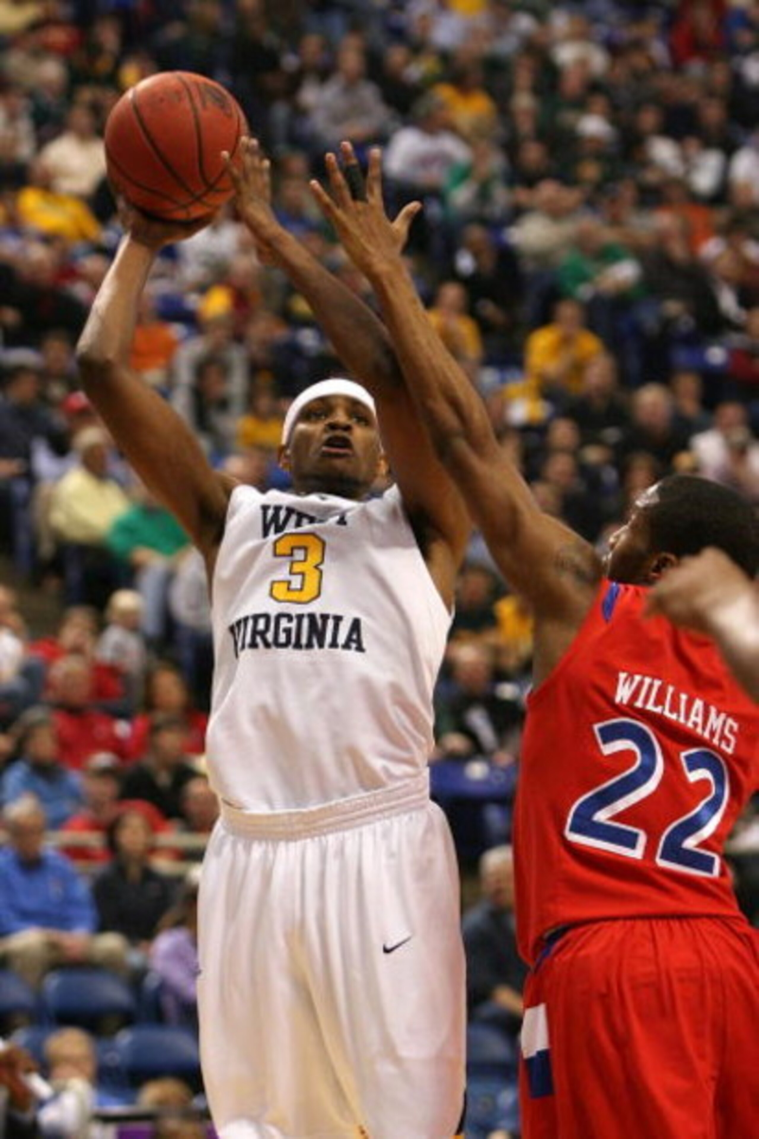 MINNEAPOLIS - MARCH 20:  Devin Ebanks #3 of the West Virginia Moutaineers attempts a shot against Paul Williams #22 of the Dayton Flyers during the first round of the NCAA Division I Men's Basketball Tournament at the Hubert H. Humphrey Metrodome on March