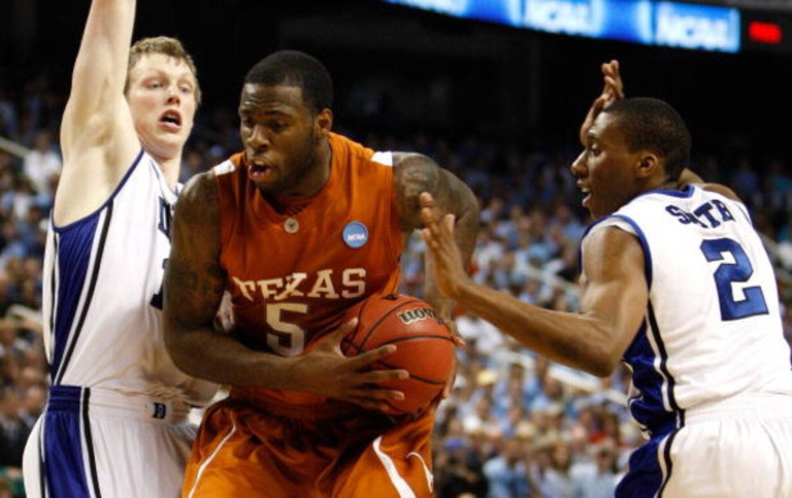 GREENSBORO, NC - MARCH 21:  Damion James #5 of the Texas Longhorns drives between Kyle Singler #12 and Nolan Smith #2 of the Duke Blue Devils during the second round of the NCAA Division I Men's Basketball Tournament at the Greensboro Coliseum on March 21