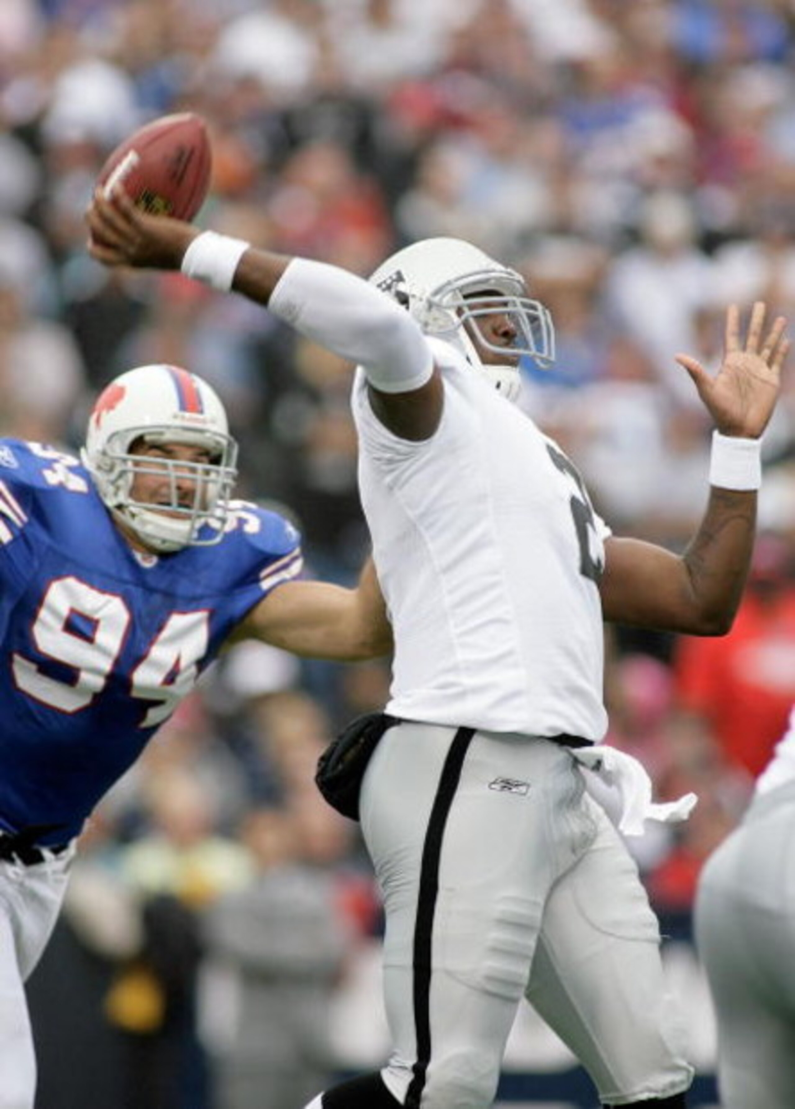 ORCHARD PARK, NY - SEPTEMBER 21: JaMarcus Russell #2 of the Oakland Raiders throws a pass with pressure from Aaron Schobel #94 of the Buffalo Bills on September 21, 2008 at Ralph Wilson Stadium in Orchard Park, New York. Buffalo won 24-23. (Photo by Rick 