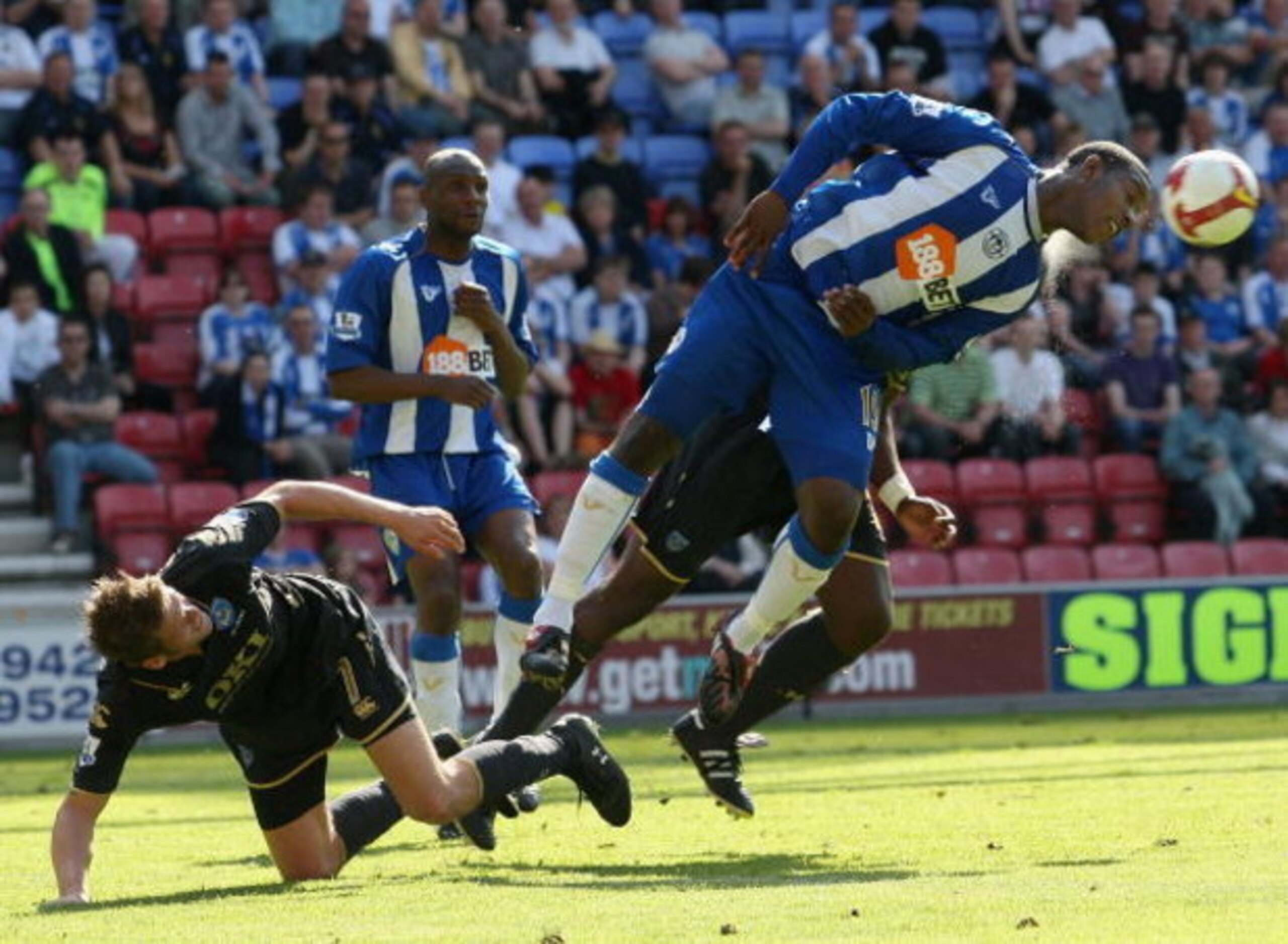 WIGAN, ENGLAND - MAY 24:  Titus Bramble (R) of Wigan heads away from Hermann Hreidarsson of Portsmouth during the Barclays Premier League match between Wigan Athletic and Portsmouth at the JJB Stadium on May 24, 2009 in Wigan, England.  (Photo by Hamish B