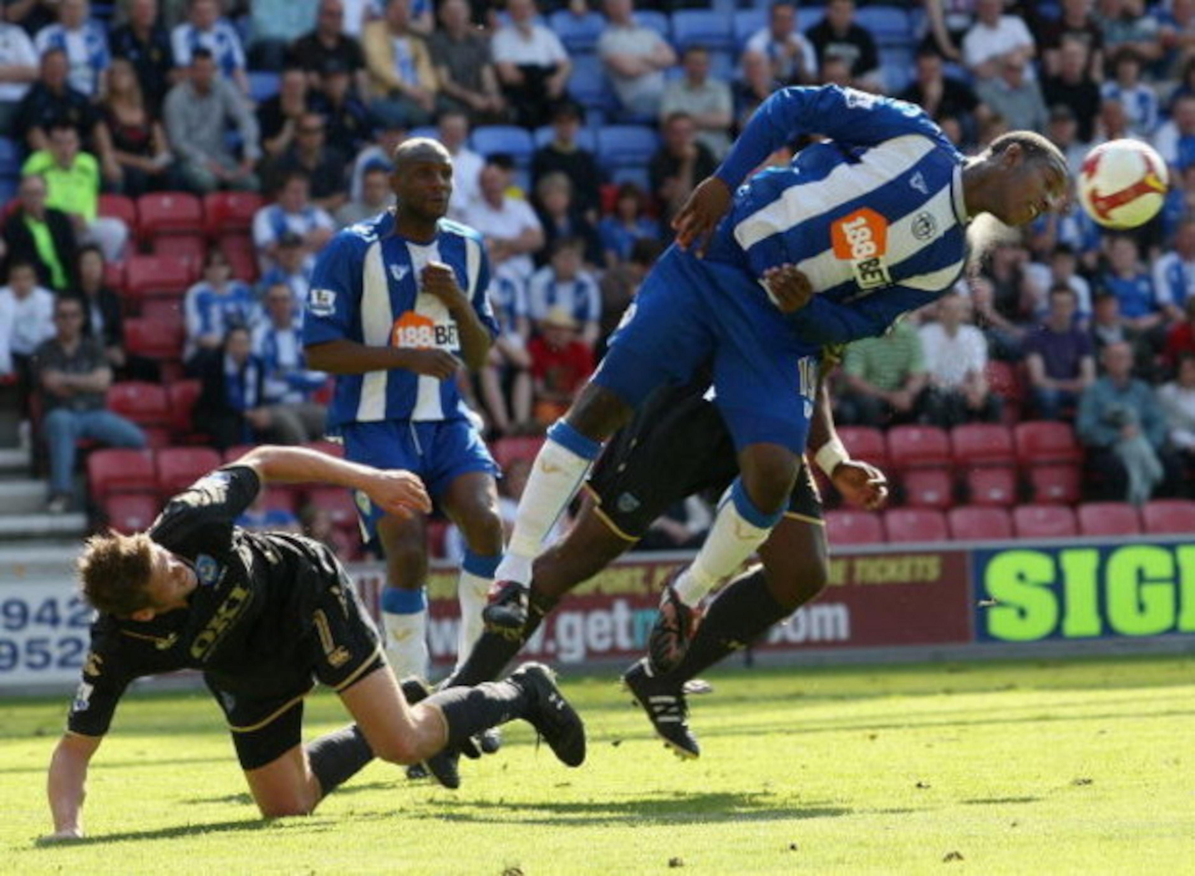 WIGAN, ENGLAND - MAY 24:  Titus Bramble (R) of Wigan heads away from Hermann Hreidarsson of Portsmouth during the Barclays Premier League match between Wigan Athletic and Portsmouth at the JJB Stadium on May 24, 2009 in Wigan, England.  (Photo by Hamish B