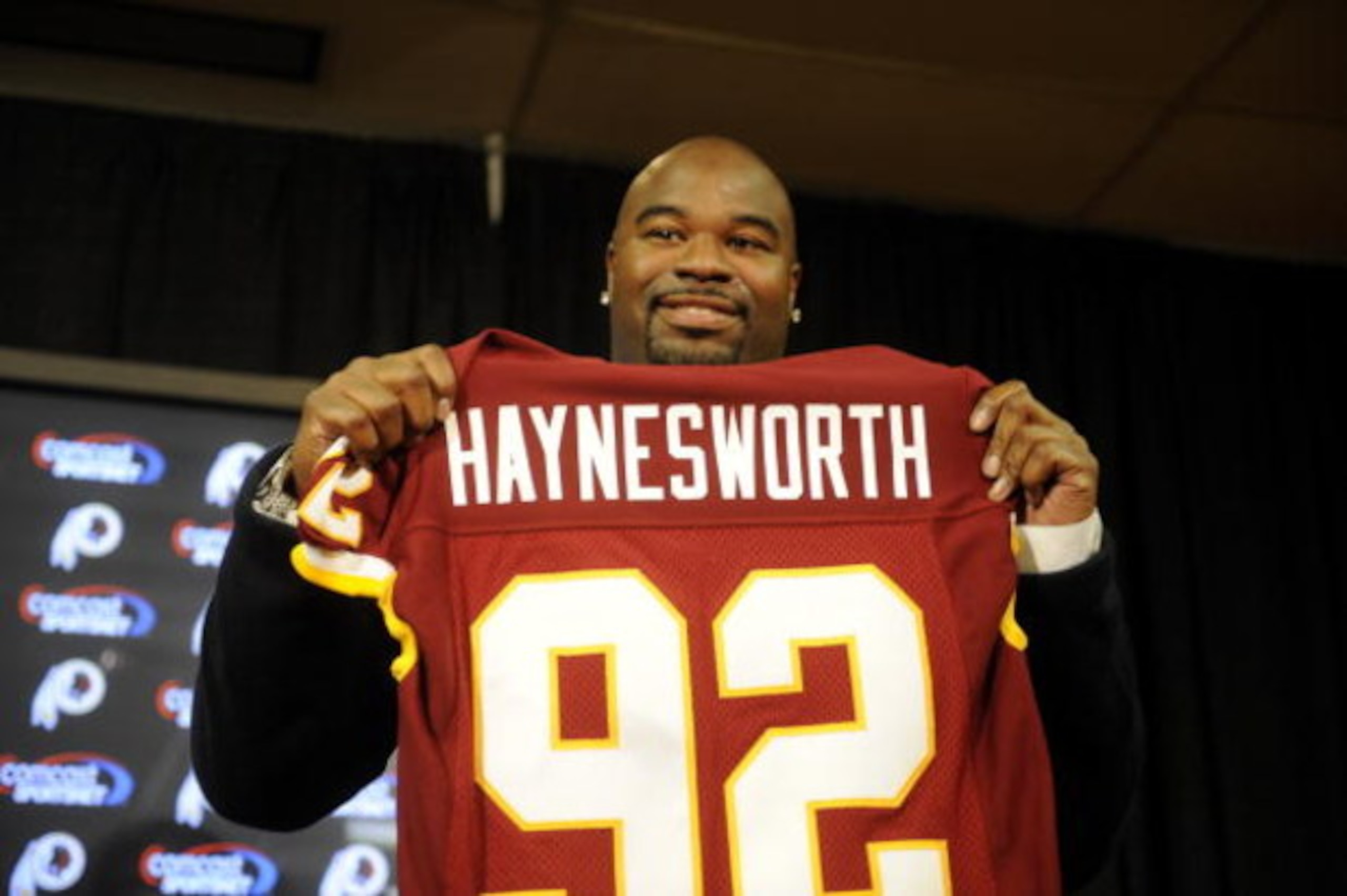 ASHBURN, VA - FEBRUARY 27:  Albert Haynesworth posese with his new jersey at a press conference after signing a 7-year contract worth approximately $100 million with the Washington Redskins on February 27, 2009 at Redskins Park in Ashburn, Virginia.  (Pho