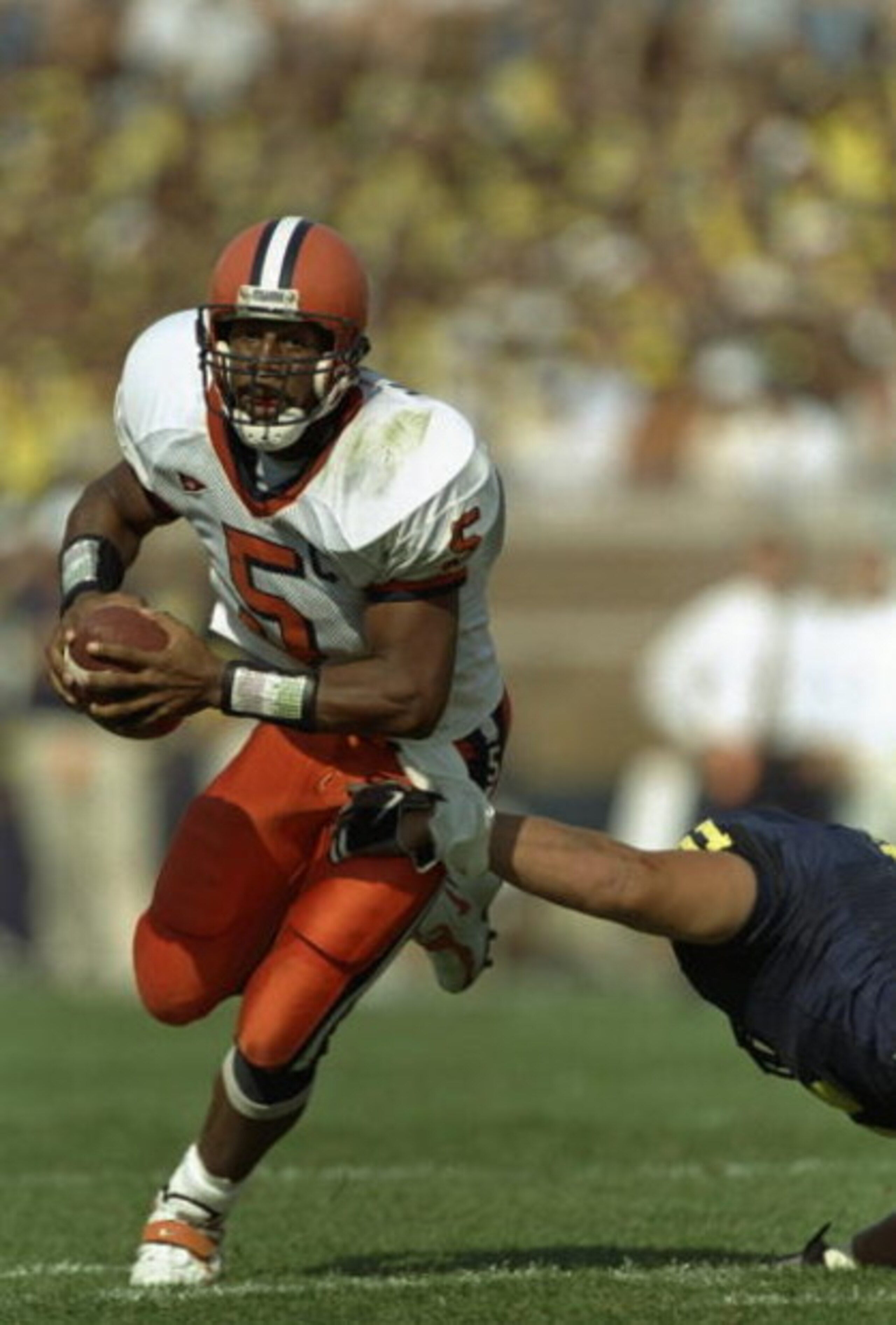 12 Sep 1998: Quarterback Donovan McNabb #5 of the Syracuse Orangeman grips the ball as he avoids being tackled during the game against Michigan Wolverines at Michigan Stadium in Ann Arbor, Michigan. Syracuse defeated Michigan 38-26. 12 Sep 1998: Quarterback Donovan McNabb #5 of the Syracuse Orangeman grips the ball as he avoids being tackled during the game against Michigan Wolverines at Michigan Stadium in Ann Arbor, Michigan. Syracuse defeated Michigan 38-26.