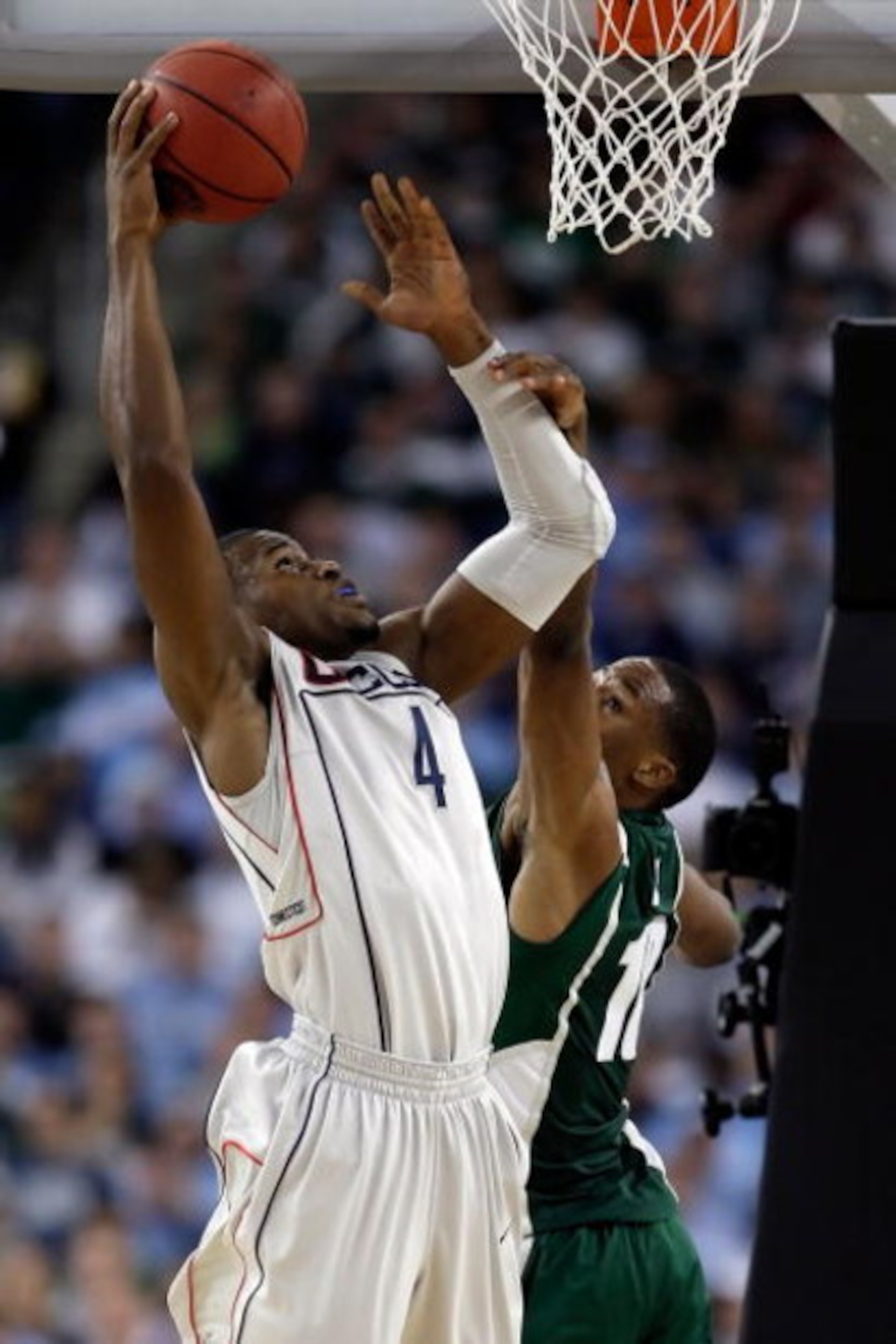 DETROIT - APRIL 04:  Jeff Adrien #4 of the Connecticut Huskies goes up for a shot over Delvon Roe #10 of the Michigan State Spartans during the National Semifinal game of the NCAA Division I Men's Basketball Championship at Ford Field on April 4, 2009 in 
