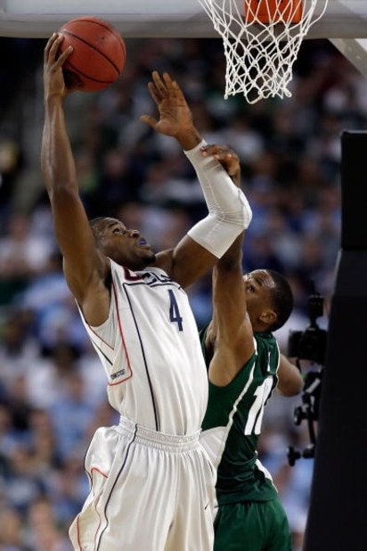 DETROIT - APRIL 04:  Jeff Adrien #4 of the Connecticut Huskies goes up for a shot over Delvon Roe #10 of the Michigan State Spartans during the National Semifinal game of the NCAA Division I Men's Basketball Championship at Ford Field on April 4, 2009 in 