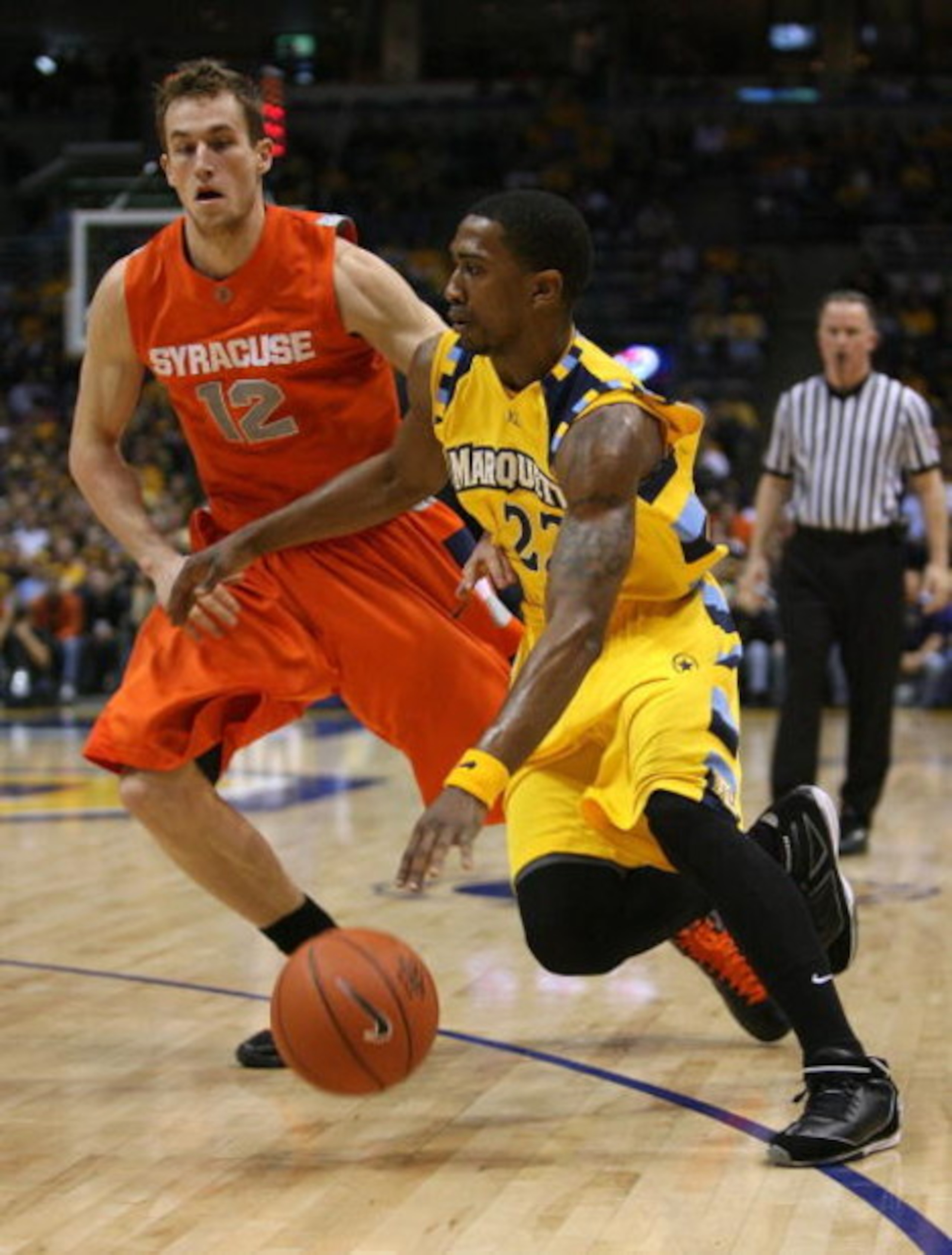 MILWAUKEE - MARCH 07: Jerel McNeal #22 of the Marquette Golden Eagles drives around Kristof Ongenaet #12 of the Syracuse Orange on March 7, 2009 at the Bradley Center in Milwaukee, Wisconsin. Syracuse defeated Marquette 86-79 in overtime. (Photo by Jonath