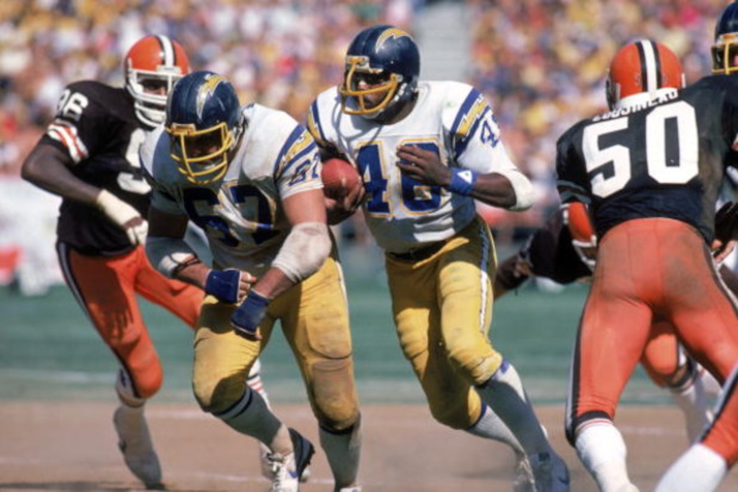 SAN DIEGO - SEPTEMBER 25:  Running back Chuck Muncie #48 of the San Diego Chargers runs behind the protection of teammate offensive guard Ed White #67 during a game agianst the Cleveland Browns at Jack Murphy Stadium on September 25, 1983 in San Diego, Ca