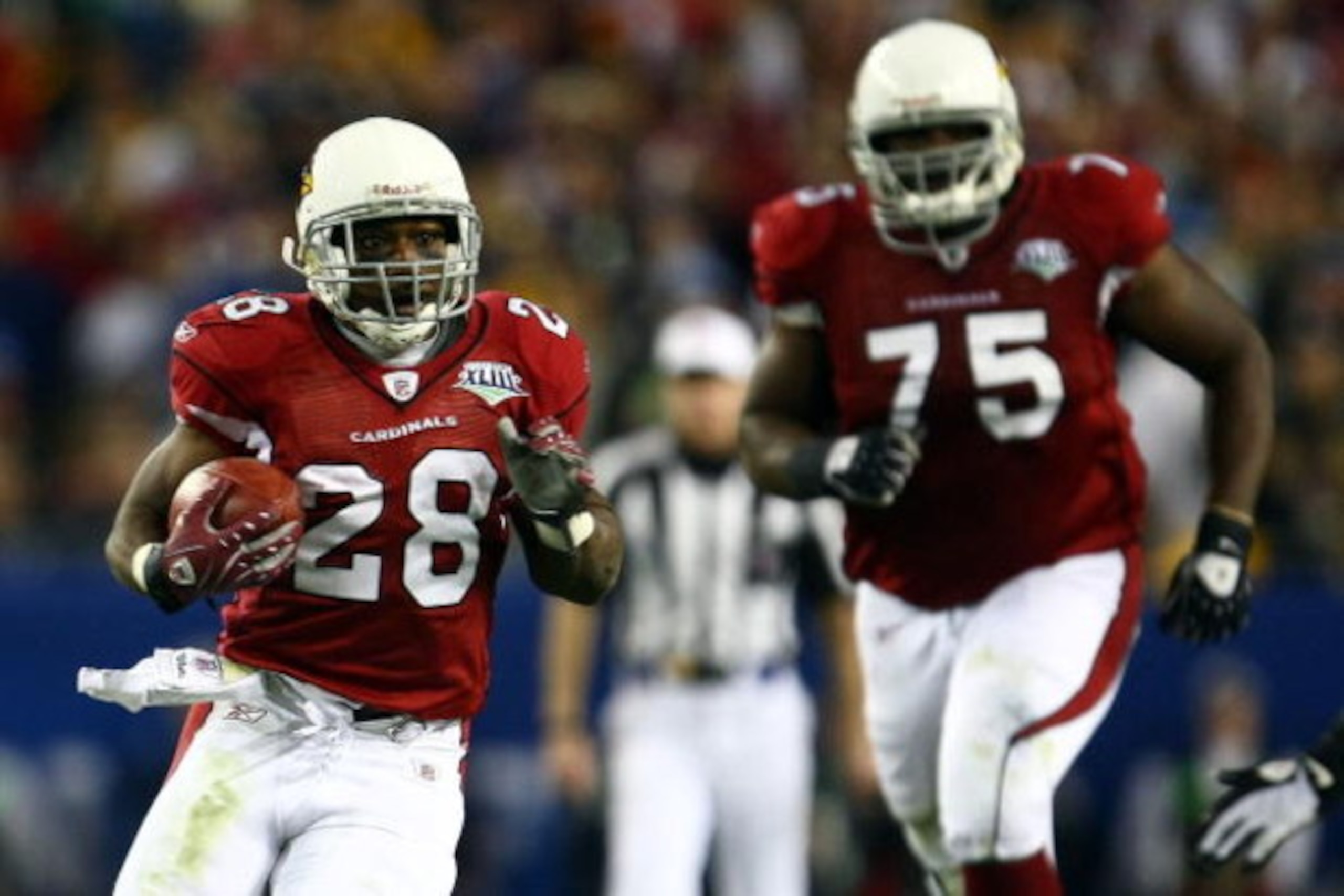 TAMPA, FL - FEBRUARY 01:  Running back J.J. Arrington #28 of the Arizona Cardinals runs the ball in front of teammate Levi Brown #75 against the Pittsburgh Steelers during Super Bowl XLIII on February 1, 2009 at Raymond James Stadium in Tampa, Florida.  (