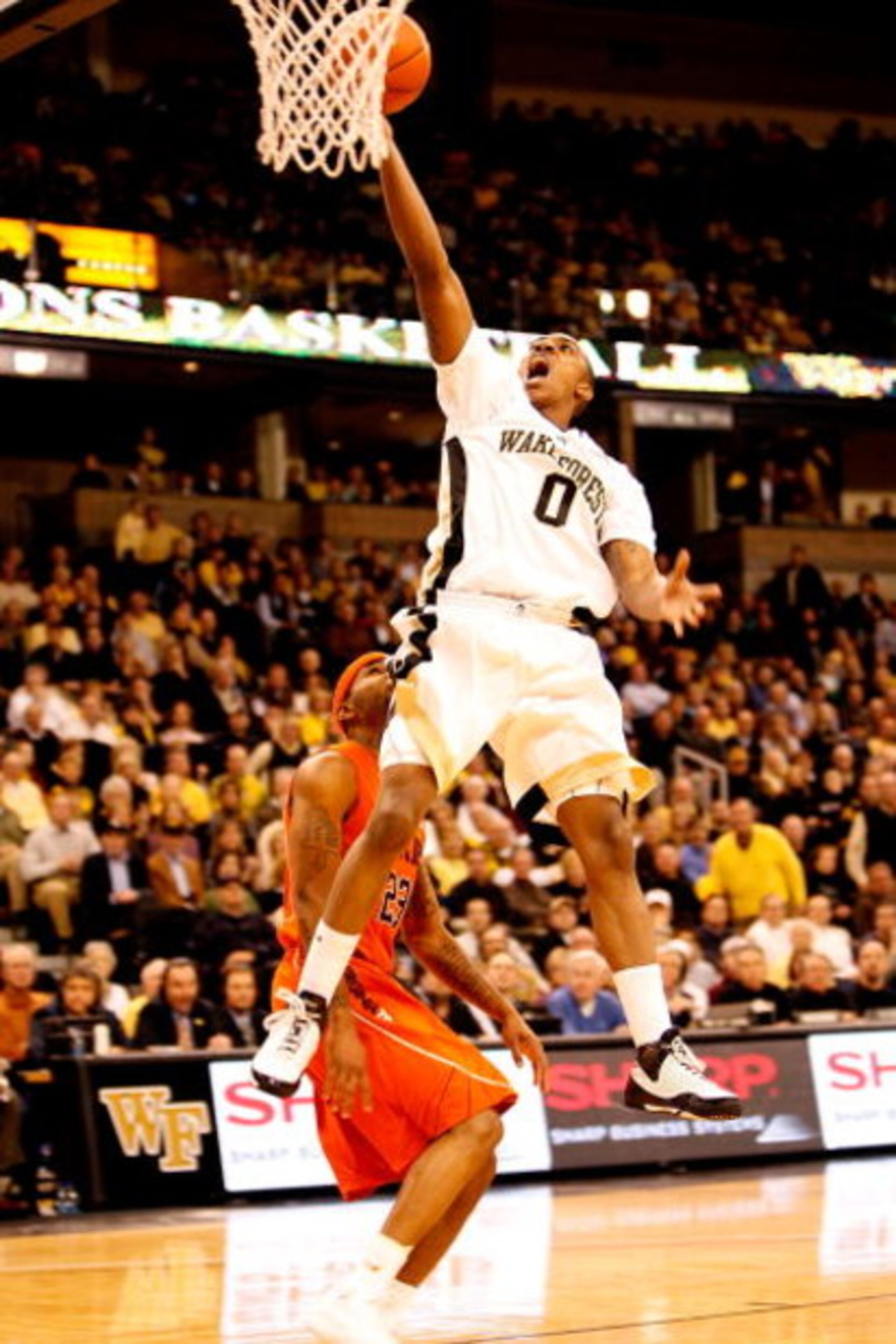WINSTON-SALEM, NC - JANUARY 21: Malcolm Delaney #23 of the Virginia Tech Hokies watches as Jeff Teague #0 of the Wake Forest Demon Deacons goes to the basket during their game at Lawrence Joel Coliseum on January 21, 2009 in Winston-Salem, North Carolina WINSTON-SALEM, NC - JANUARY 21: Malcolm Delaney #23 of the Virginia Tech Hokies watches as Jeff Teague #0 of the Wake Forest Demon Deacons goes to the basket during their game at Lawrence Joel Coliseum on January 21, 2009 in Winston-Salem, North Carolina