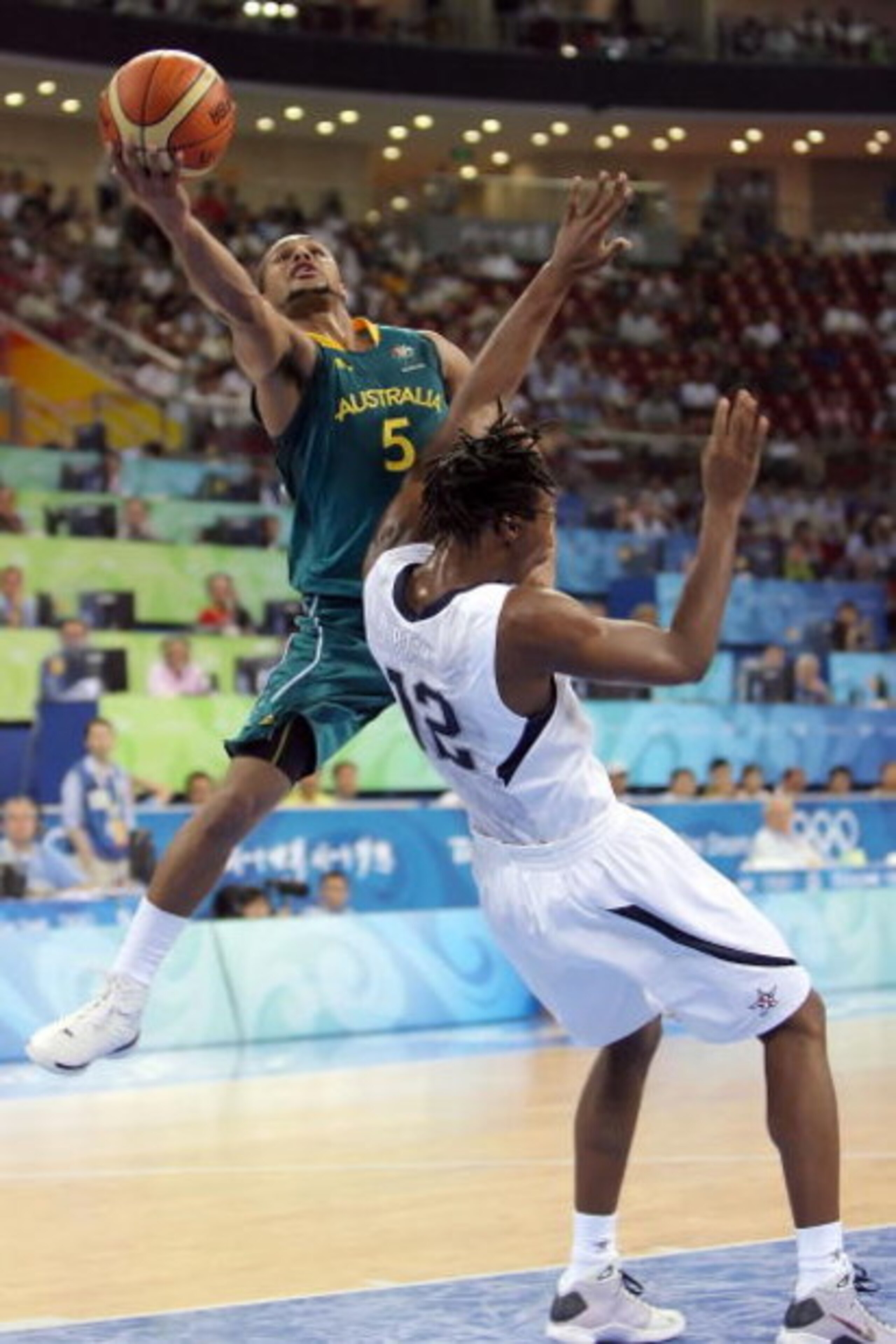 BEIJING - AUGUST 20: Patrick Mills #5 of Australia drives to the basket over Chris Bosh #12 of the United States during the men's basketball quarterfinal game at the Olympic Basketball Gymnasium during Day 12 of the Beijing 2008 Olympic Games on August 2 BEIJING - AUGUST 20: Patrick Mills #5 of Australia drives to the basket over Chris Bosh #12 of the United States during the men's basketball quarterfinal game at the Olympic Basketball Gymnasium during Day 12 of the Beijing 2008 Olympic Games on August 2