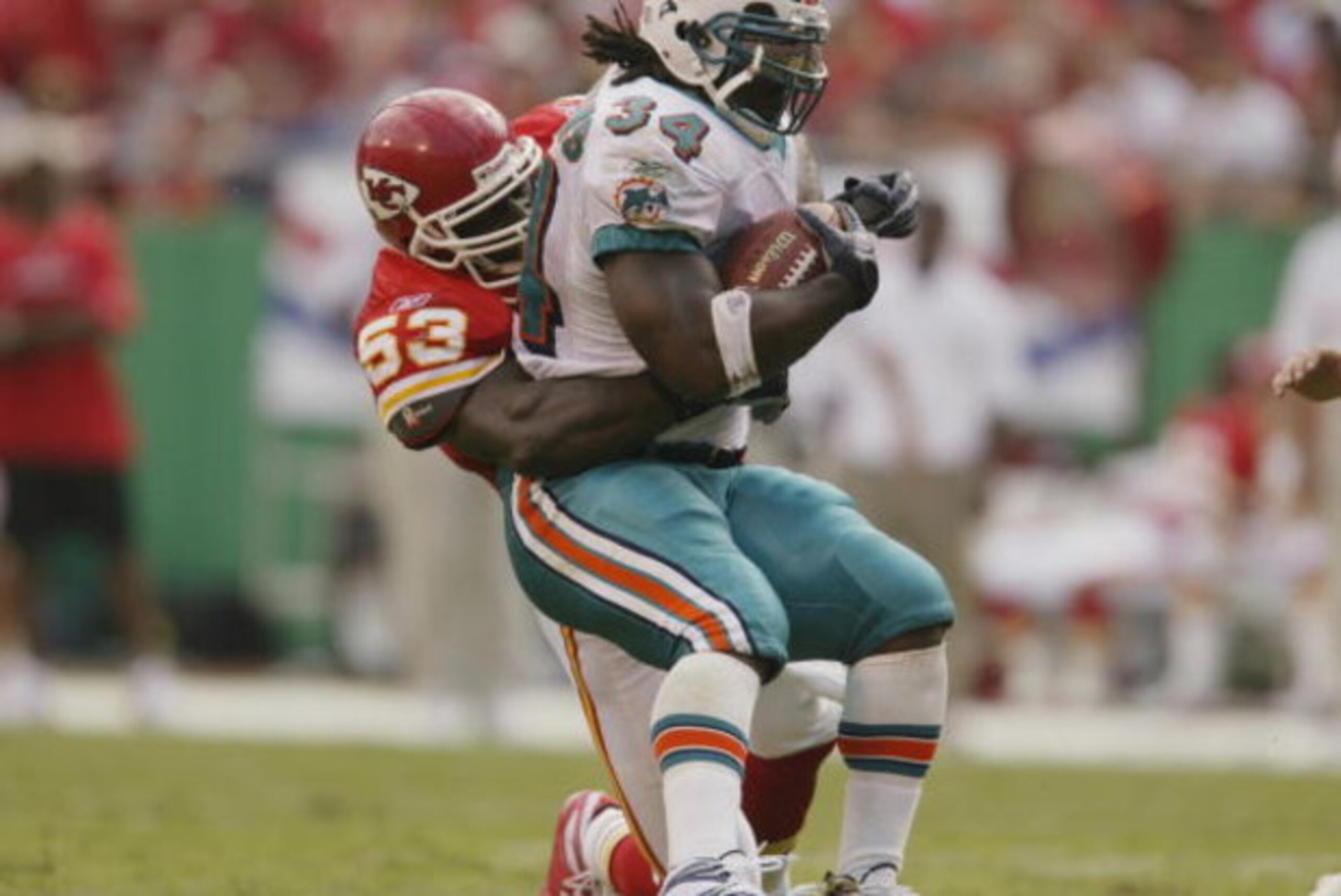 KANSAS CITY, MO - SEPTEMBER 29:  Linebacker Marvcus Patton #53 of the Kansas City Chiefs tackles running back Ricky Williams #34 of the Miami Dolphins during the NFL game on September 29, 2002 at Arrowhead Stadium in Kansas City, Missouri.  The Chiefs won