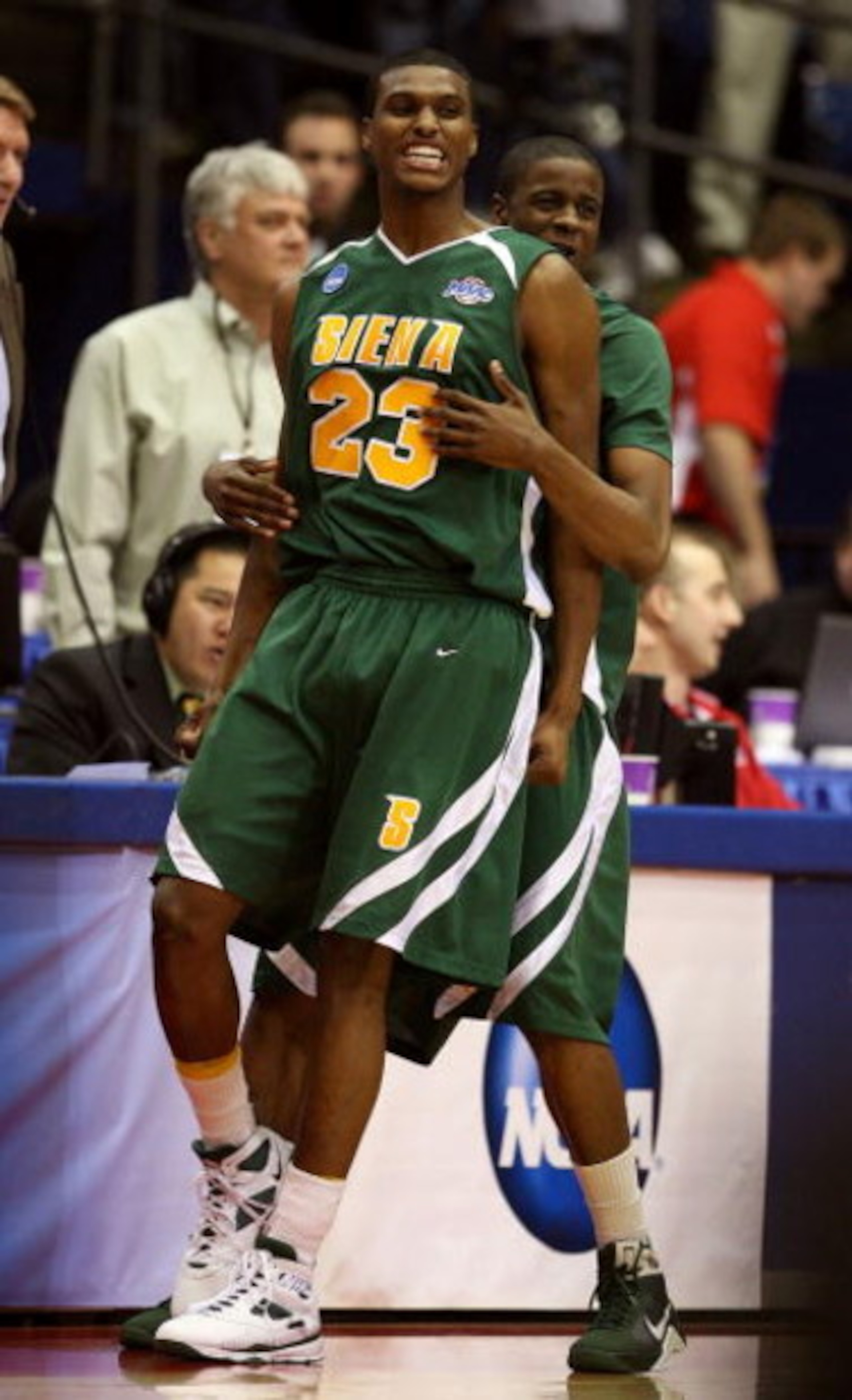 DAYTON, OH - MARCH 20: Edwin Ubiles #23 and Clarence Jackson #13 of the Siena Saints celebrate on the court after defeating the Ohio State Buckeyes in overtime during the first round of the NCAA Division I Men's Basketball Tournament at the University of 