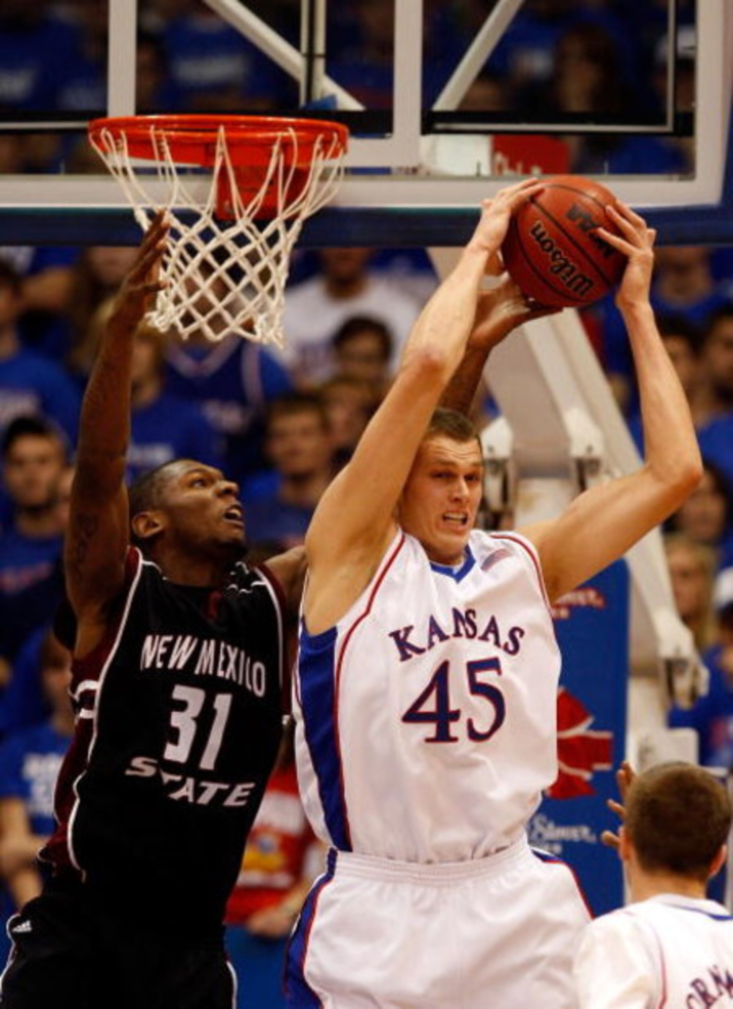 LAWRENCE, KS - DECEMBER 03: Cole Aldrich #45 of the Kansas Jayhawks grabs a rebound as Wendell McKines #31 of the New Mexico State Aggies defends during the second half of the game on December 3, 2008 at Allen Fieldhouse in Lawrence, Kansas. (Photo by Jam