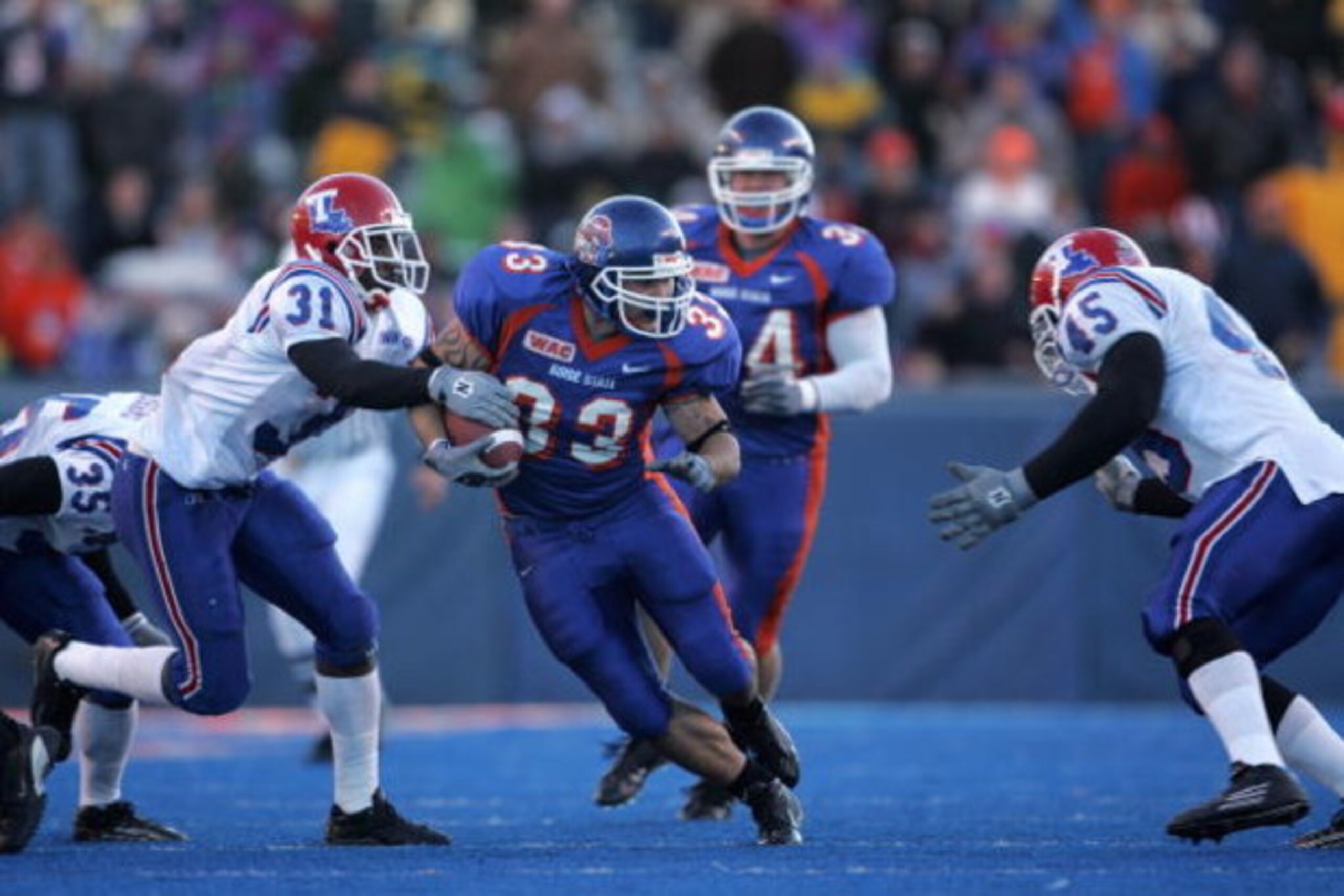 BOISE, ID - NOVEMBER 20:  Running back Jon Helmandollar #33 of Boise State carries the ball against strong saftey Bo Cox #31 of Louisiana Tech during the game at Bronco Stadium on November 20, 2004 in Boise, Idaho. Boise State defeated Louisiana Tech 55-1