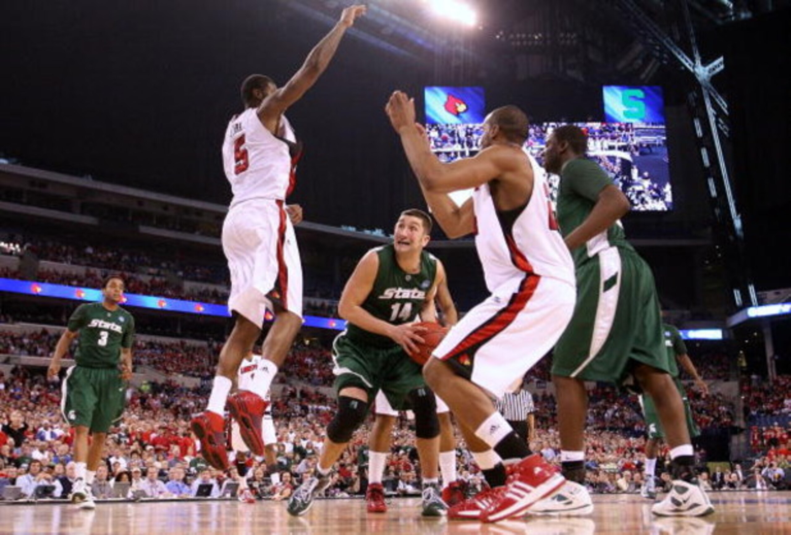 INDIANAPOLIS - MARCH 29:  Goran Suton #14 of the Michigan State Spartans looks to go up for a shot attempt against Earl Clark #5 and Samardo Samuels #24 of the Louisville Cardinals  during the fourth round of the NCAA Division I Men's Basketball Tournamen
