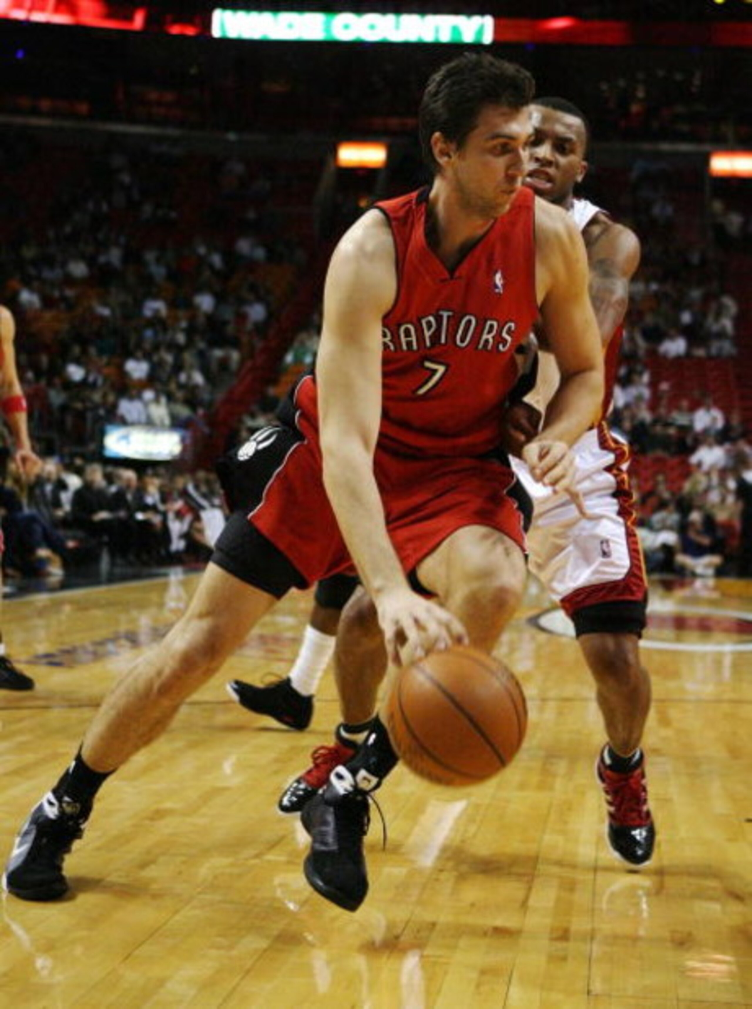 MIAMI - NOVEMBER 19:  Andrea Bargnani #7 of the Toronto Raptors drives past Daequan Cook #14 of the Miami Heat at American Airlines Arena on November 19, 2008 in Miami, Florida. The Raptors defeated the Heat 101-95. NOTE TO USER: User expressly acknowledg