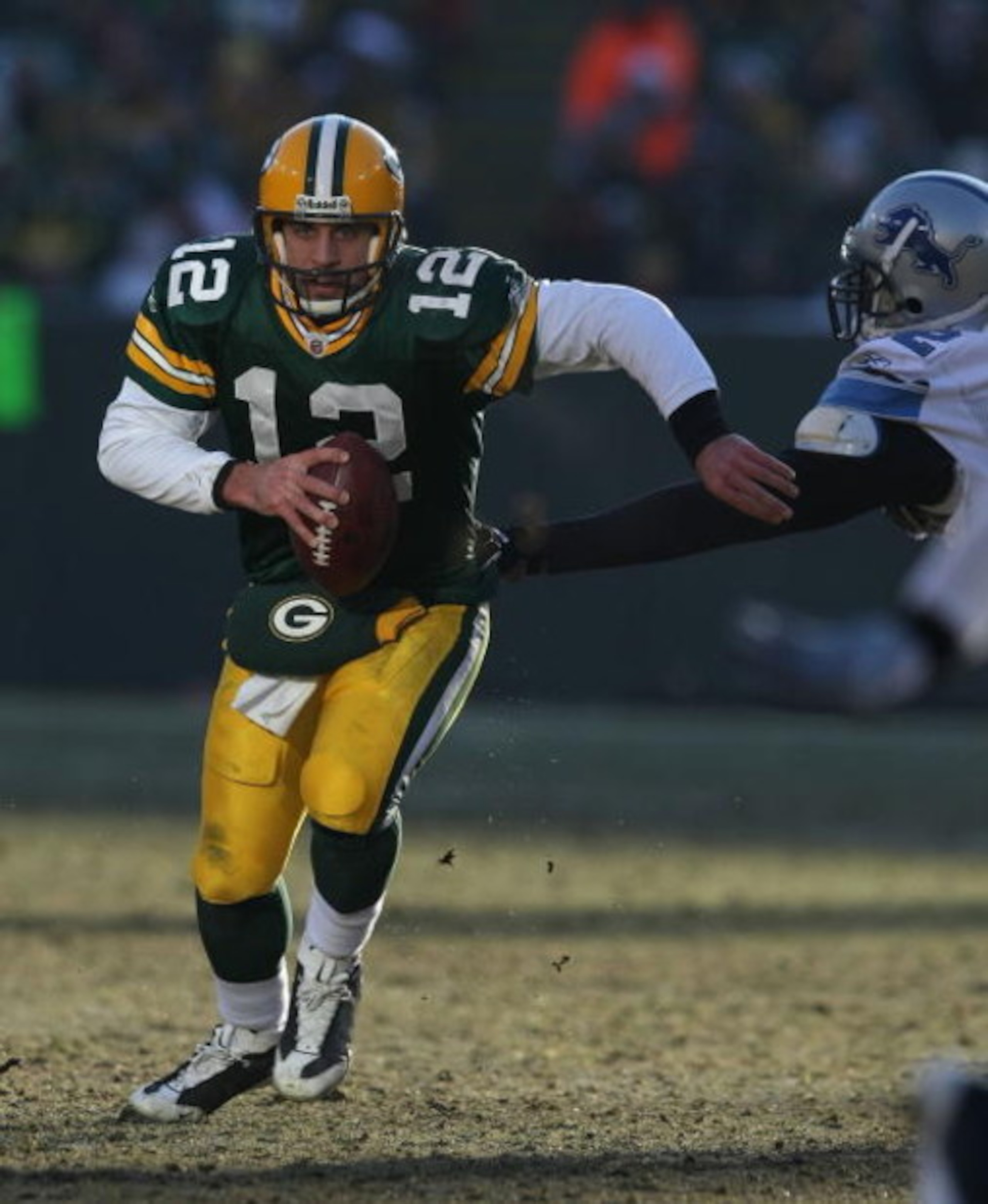 GREEN BAY, WI - DECEMBER 28: Aaron Rodgers #12 of the Green Bay Packers breaks away from Cliff Avril #92 of the Detroit Lions on December 28, 2008 at Lambeau Field in Green Bay, Wisconsin. The Packers defeated the Lions 31-21. (Photo by Jonathan Daniel/Ge
