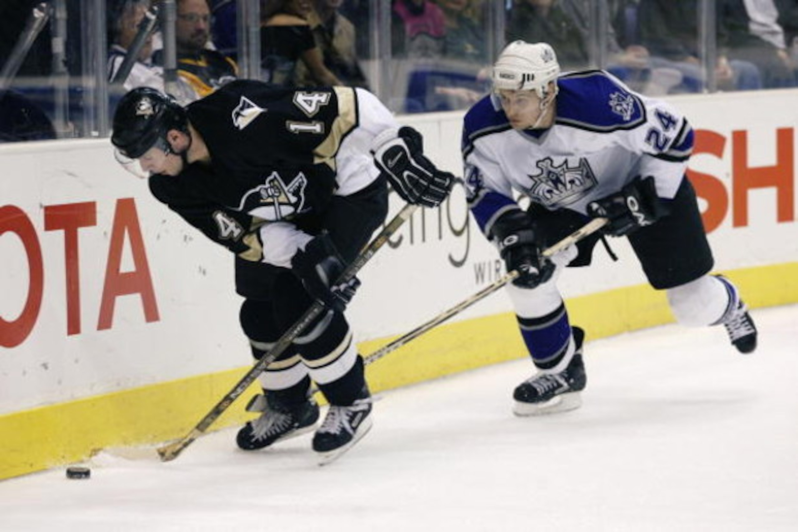 LOS ANGELES - DECEMBER 14:  Milan Kraft #14 of the Pittsburgh Penguins plays the puck against the boards while being pursued by Alexander Frolov #24 of the Los Angeles Kings during the NHL game at Staples Center on December 14, 2002 in Los Angeles, Califo