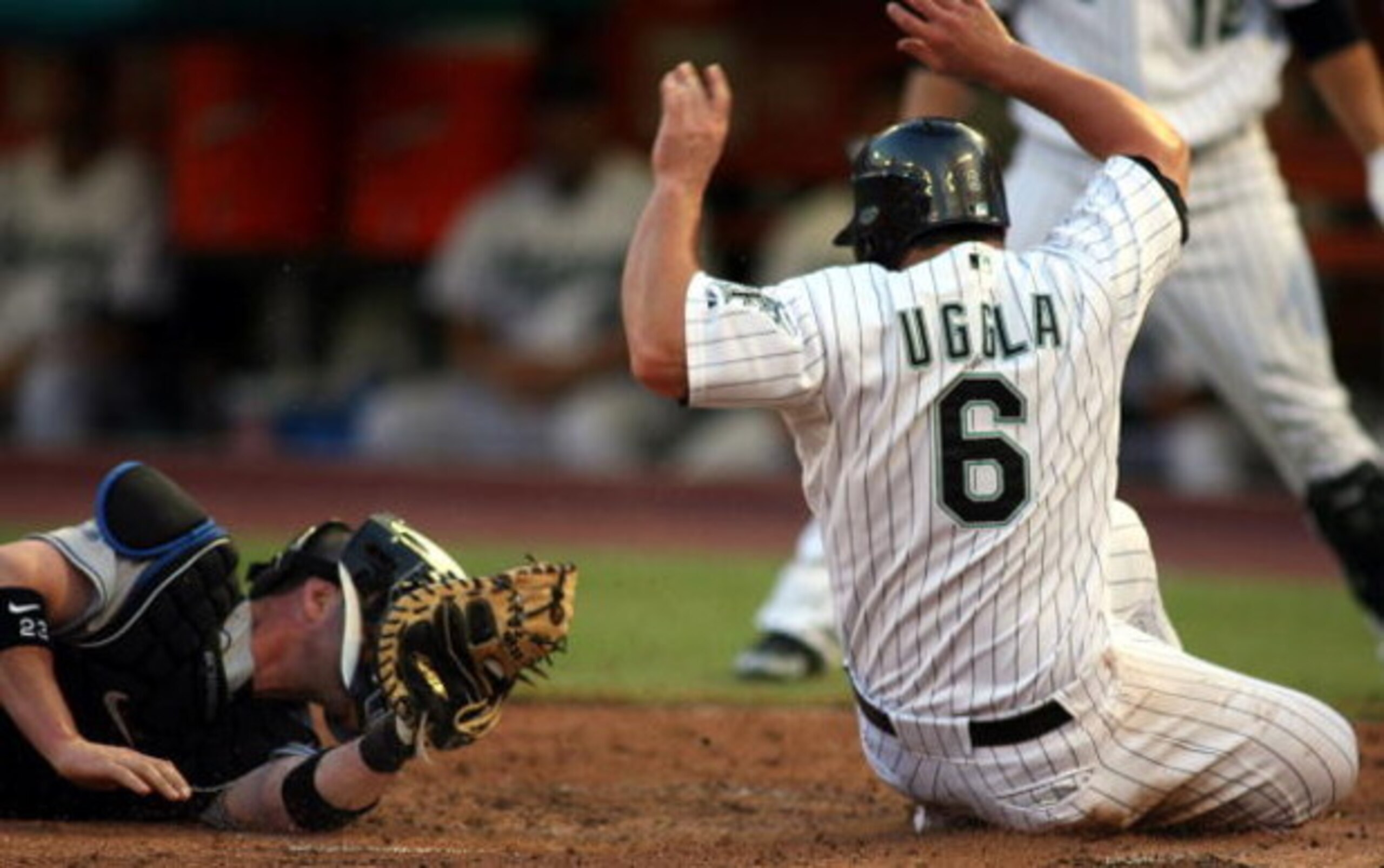 MIAMI - JULY 30: Dan Uggla #6 of the Florida Marlins avoids a tag by catcher Brian Schneider #23 of the New York Mets in the third inning on July 30, 2008 at Dolphin Stadium in Miami, Florida. The Marlins defeated the Mets 7-4. (Photo by Marc Serota/Ge MIAMI - JULY 30: Dan Uggla #6 of the Florida Marlins avoids a tag by catcher Brian Schneider #23 of the New York Mets in the third inning on July 30, 2008 at Dolphin Stadium in Miami, Florida. The Marlins defeated the Mets 7-4. (Photo by Marc Serota/Ge