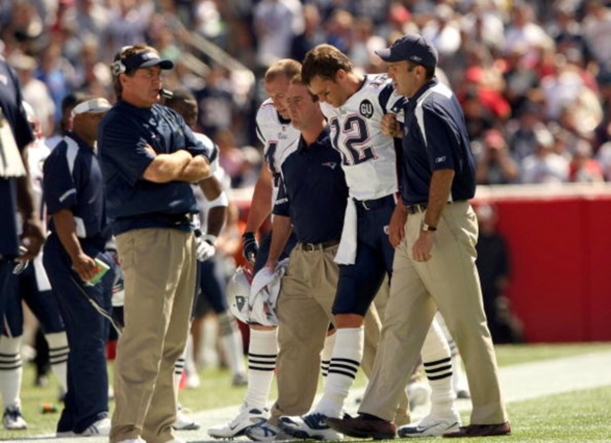 FOXBORO, MA - SEPTEMBER 7:  Quarterback Tom Brady #12 of the New England Patriots walks off the field with the aid of the Patriots staff after being injured on a play during their NFL game against the Kansas City Chiefs on September 7, 2008 at Gillette St