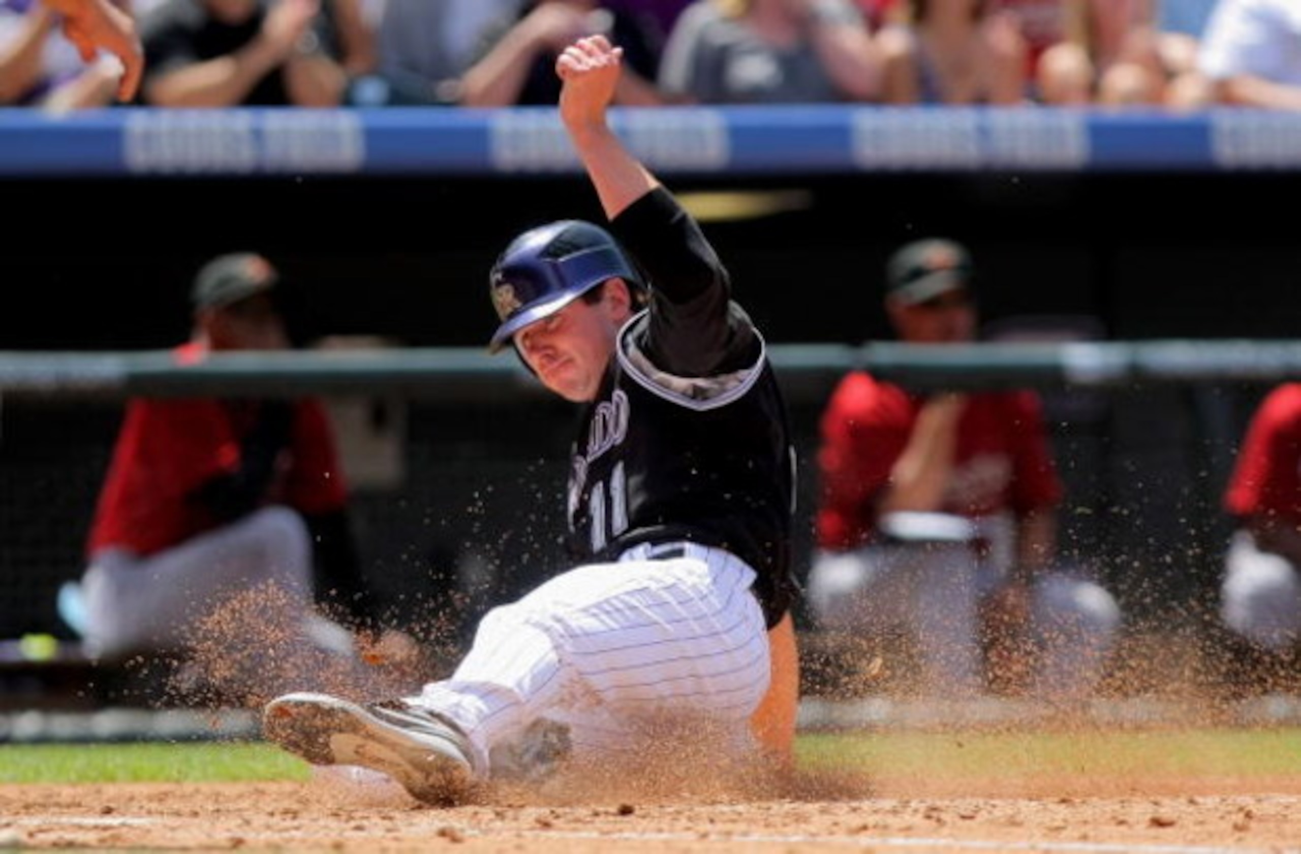 DENVER - MAY 14:  Brad Hawpe #11 of the Colorado Rockies slides home to score against the Houston Astros during MLB action at Coors Field on May 14, 2009 in Denver, Colorado. The Astros defeated the Rockies 5-3.  (Photo by Doug Pensinger/Getty Images)