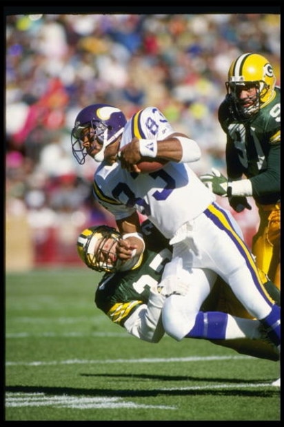 28 Oct 1990: MINNESOTA VIKINGS WIDE RECEIVER STEVE JORDAN #83 CARRIES THE FOOTBALL AND RUNS OVER AN UNIDENTIFIED GREEN BAY PACKERS DEFENDER, DURING THE VIKINGS 24-10 LOSS AT Milwaukee County Stadium in Milwaukee, Wisconsin.