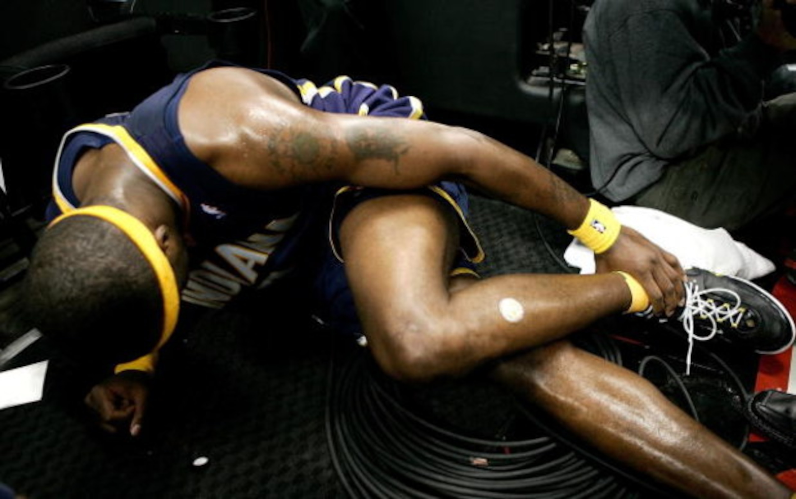 PORTLAND, OR - NOVEMBER 28:  Jermaine O'Neal #7 of the Indiana Pacers injures his ankle after falling over a Television camera operator against the Portland Trail Blazers on November 28, 2006 at the Rose Garden in Portland, Oregon.  NOTE TO USER: User exp