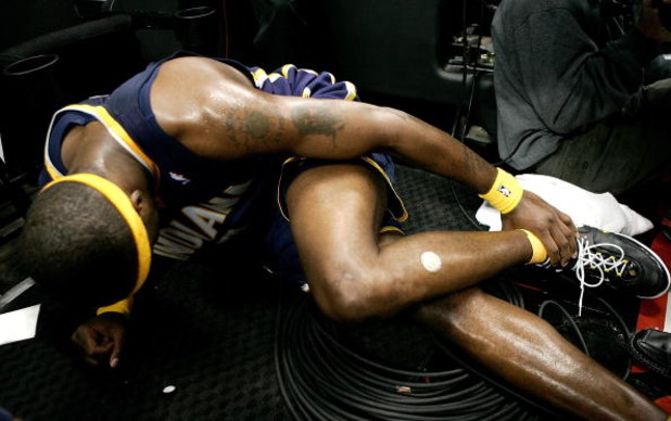 PORTLAND, OR - NOVEMBER 28:  Jermaine O'Neal #7 of the Indiana Pacers injures his ankle after falling over a Television camera operator against the Portland Trail Blazers on November 28, 2006 at the Rose Garden in Portland, Oregon.  NOTE TO USER: User exp