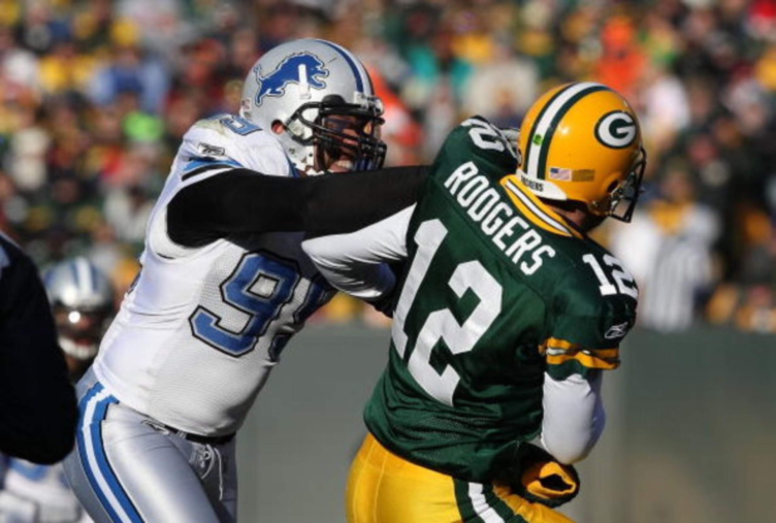 GREEN BAY, WI - DECEMBER 28: Aaron Rodgers #12 of the Green Bay Packers is hit by Dewayne White #99 of the Detroit Lions on December 28, 2008 at Lambeau Field in Green Bay, Wisconsin. The Packers defeated the Lions 31-21. (Photo by Jonathan Daniel/Getty I