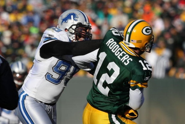 GREEN BAY, WI - DECEMBER 28: Aaron Rodgers #12 of the Green Bay Packers is hit by Dewayne White #99 of the Detroit Lions on December 28, 2008 at Lambeau Field in Green Bay, Wisconsin. The Packers defeated the Lions 31-21. (Photo by Jonathan Daniel/Getty I