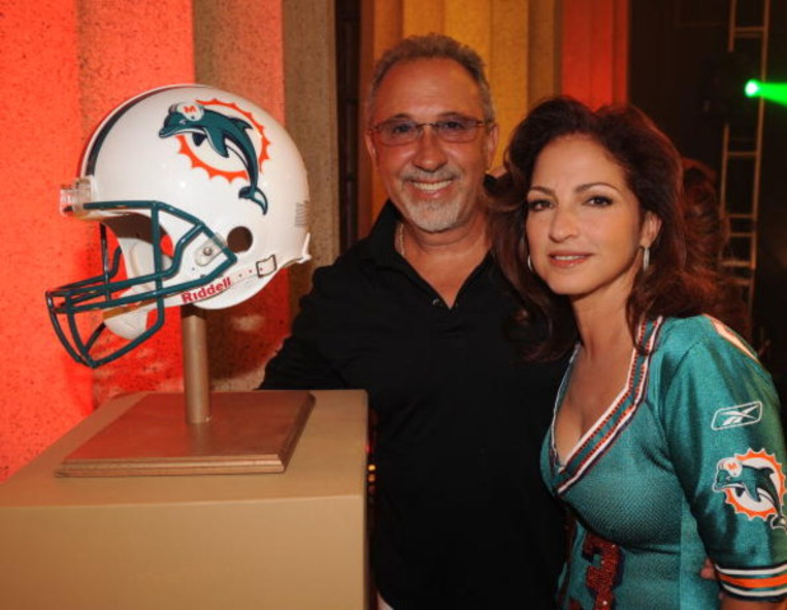 NASHVILLE, TN - JUNE 22: Emilio Estefan and Gloria Estefan pose with their team The Miami Dolphins helmet before joining Hank Williams Jr. to sing 'Are You Ready for some Football' in Spanish as part of the 40th Anniversary of Monday Night Football at Cen