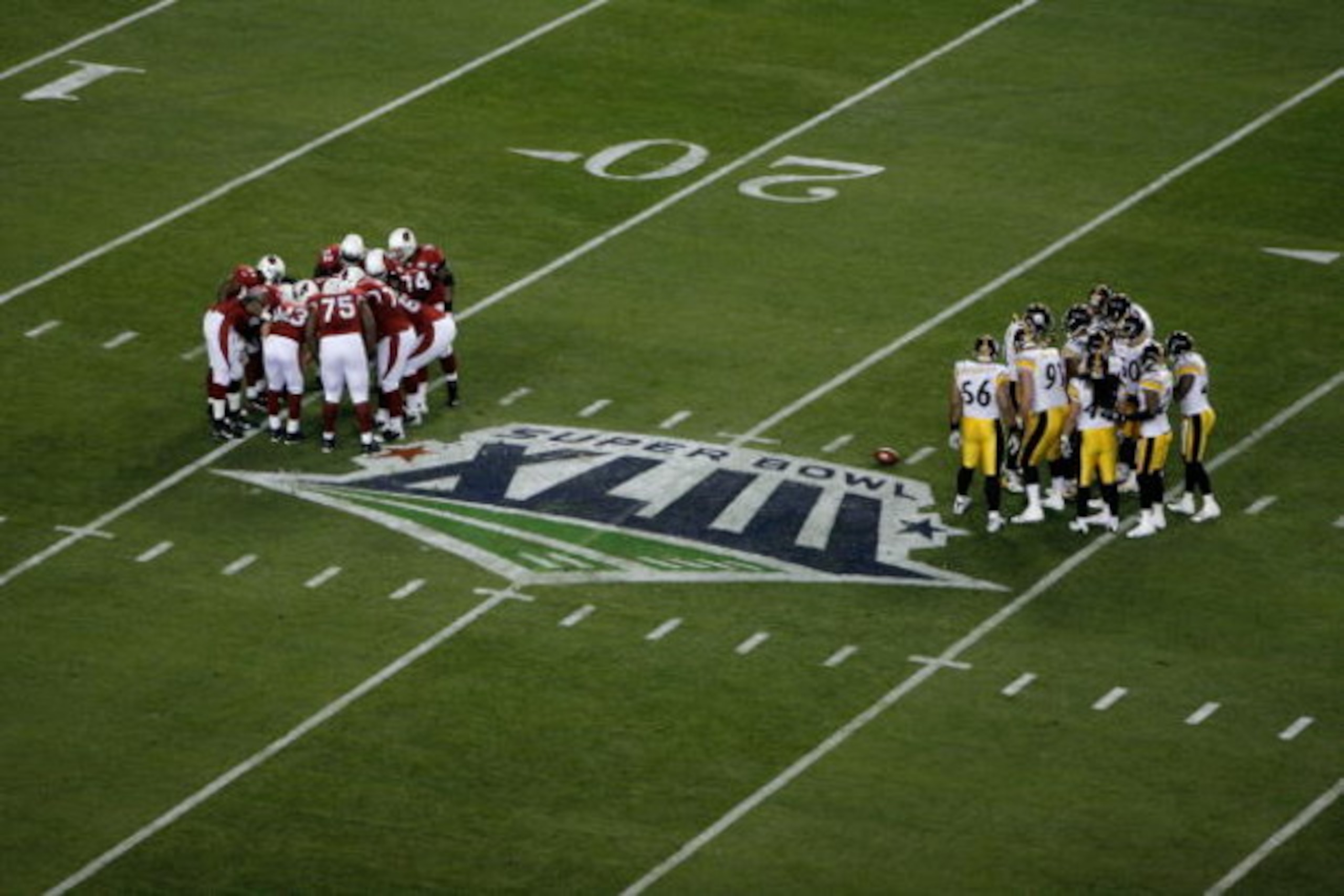 TAMPA, FL - FEBRUARY 01:  The Arizona Cardinals offensive huddle stands across from the the Pittsburgh Steelers defensive huddle during Super Bowl XLIII on February 1, 2009 at Raymond James Stadium in Tampa, Florida.  (Photo by Doug Benc/Getty Images)