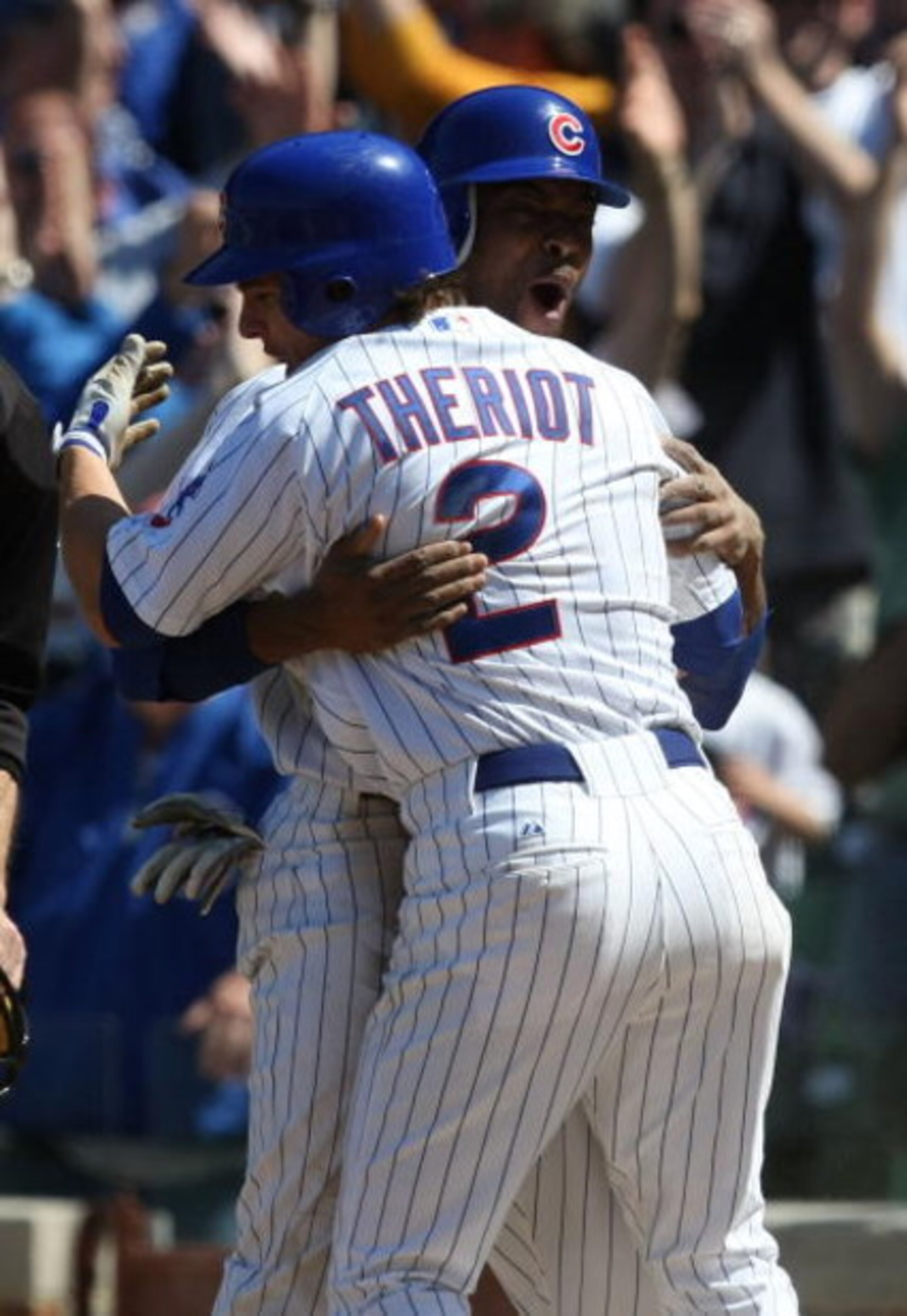 CHICAGO - MAY 16: Ryan Theriot #2 of the Chicago Cubs hugs teammate Bobby Scales #24 after Scales scored the game-winning run in the bottom of the 9th inning against the Houston Astros on May 16, 2009 at Wrigley Field in Chicago, Illinois. The Cubs defeat