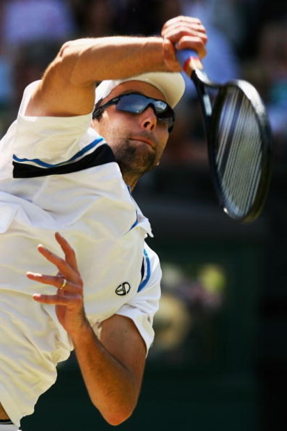 WIMBLEDON, ENGLAND - JULY 01: Ivo Karlovic of Croatia serves during the men's singles quarter final match against Roger Federer of Switzerland on Day Nine of the Wimbledon Lawn Tennis Championships at the All England Lawn Tennis and Croquet Club on July WIMBLEDON, ENGLAND - JULY 01: Ivo Karlovic of Croatia serves during the men's singles quarter final match against Roger Federer of Switzerland on Day Nine of the Wimbledon Lawn Tennis Championships at the All England Lawn Tennis and Croquet Club on July