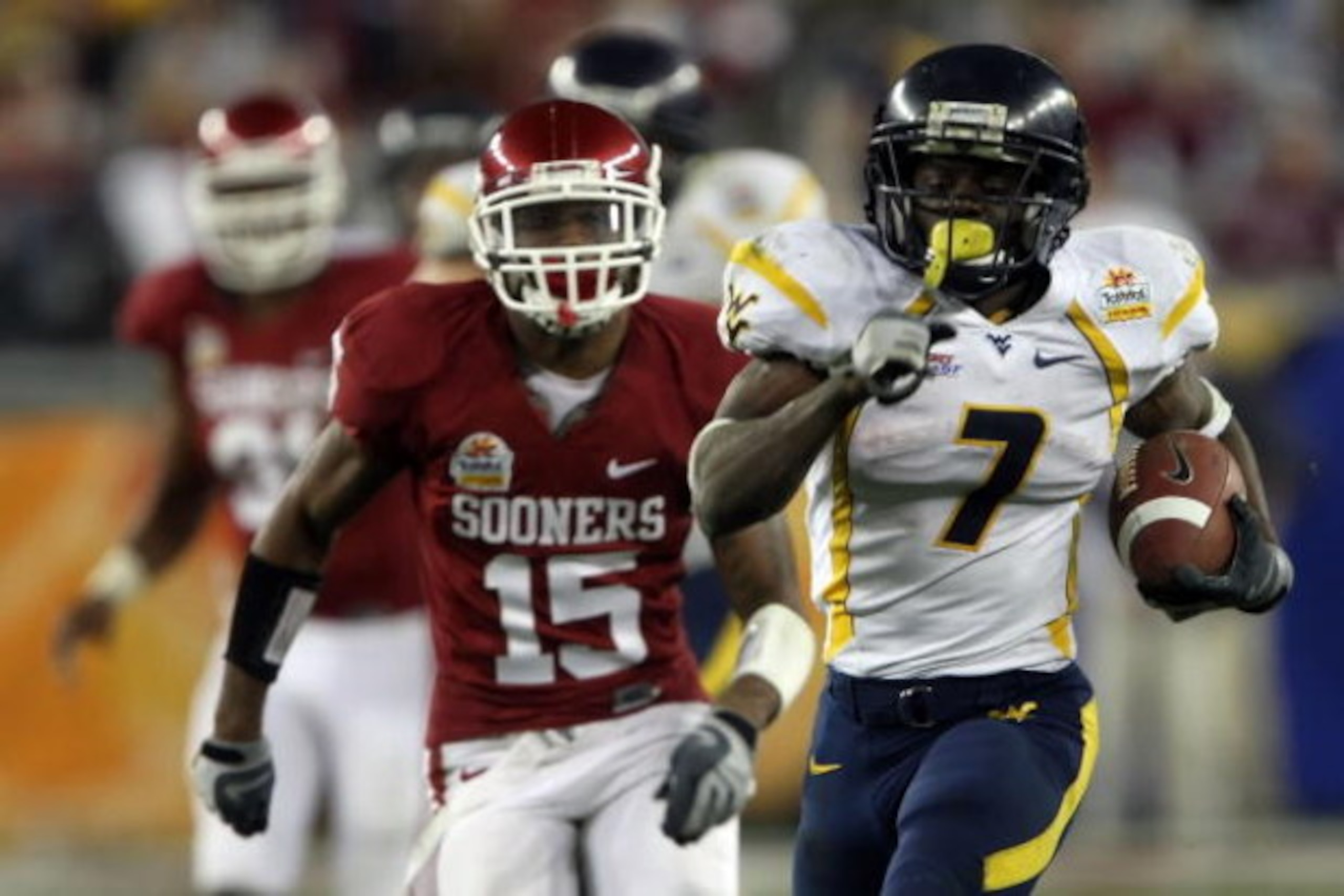 GLENDALE, AZ - JANUARY 02:  Running back Noel Devine #7 of the West Virginia Mountaineers runs for a 65-yard touchdown past Dominique Franks #15 of the Oklahoma Sooners in the second half at the Tostito's Fiesta Bowl at University of Phoenix Stadium Janua