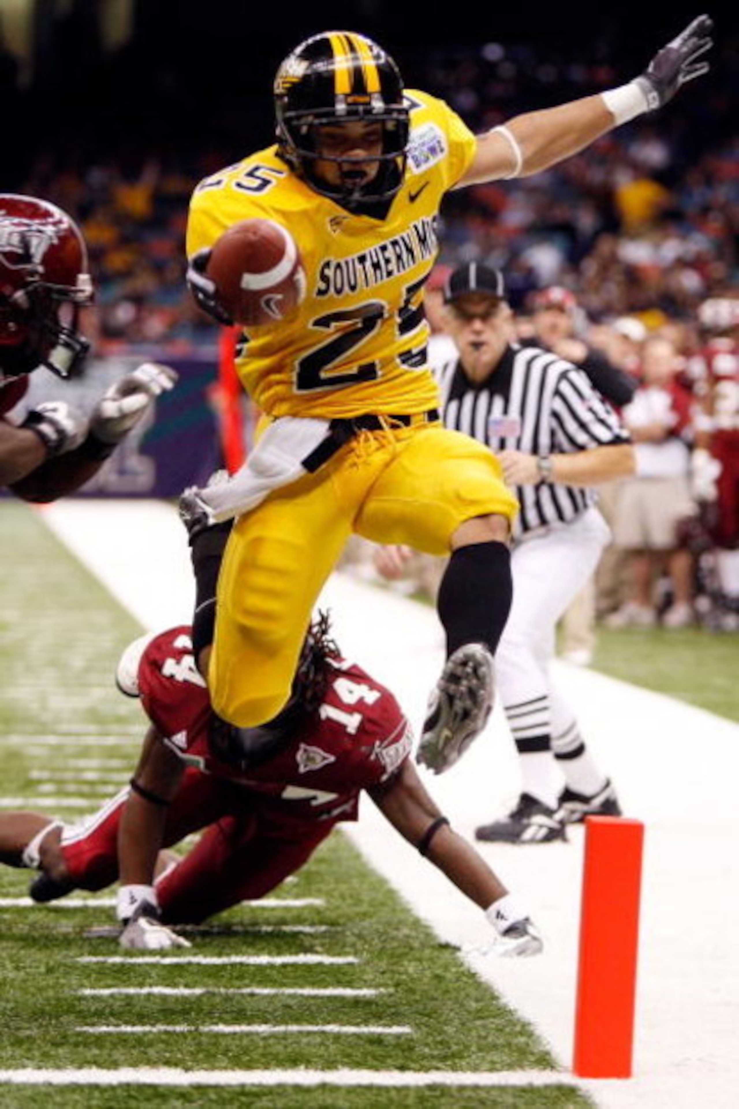 NEW ORLEANS - DECEMBER 21:  Damion Fletcher #25 of the Southern Mississippi Golden Eagles scores a touchdown over Jorrick Calvin #14 of the Troy Trojans during the R+L Carriers New Orleans Bowl on December 21, 2008 at the Superdome in New Orleans, Louisia