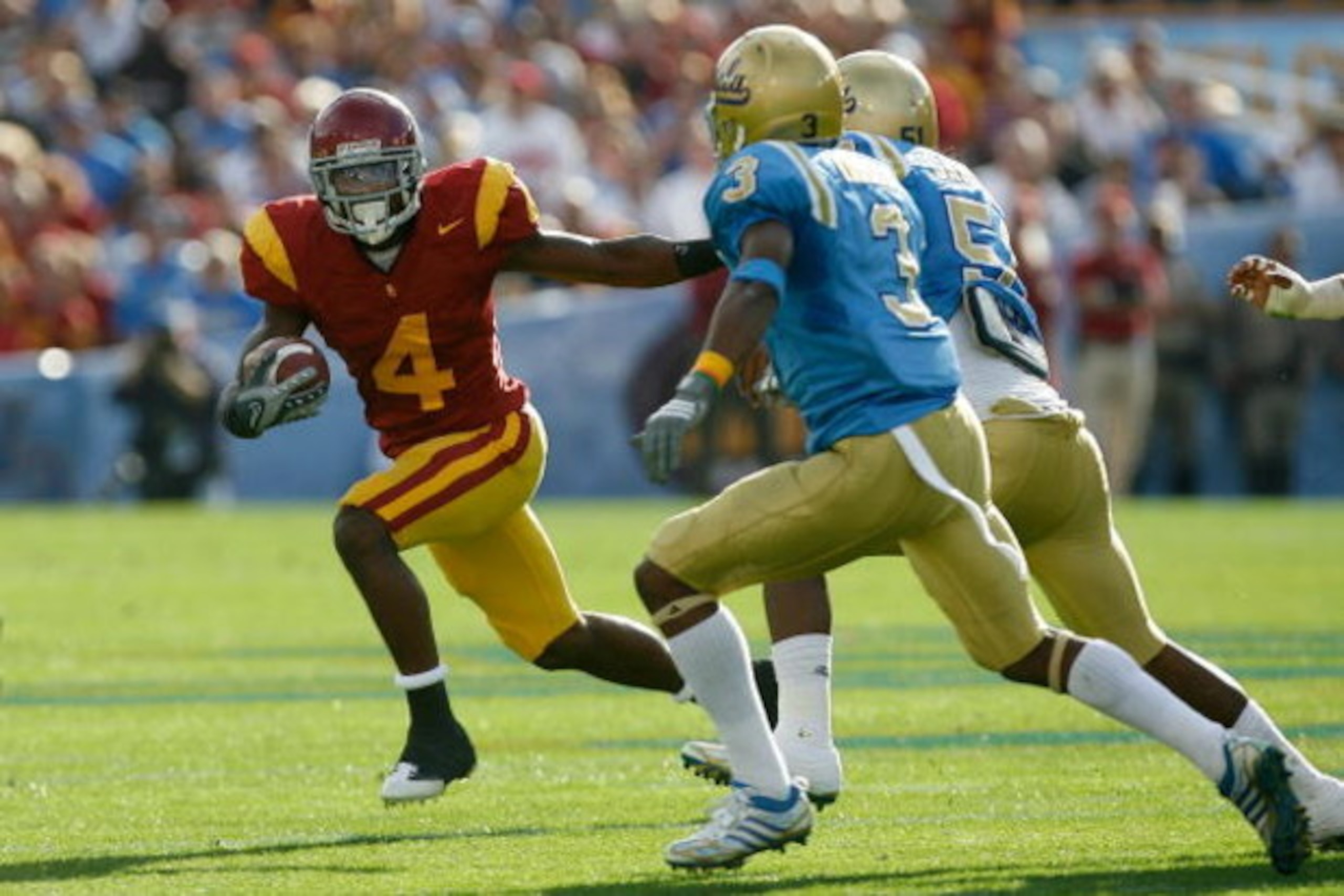PASADENA, CA - DECEMBER 06:  Joe McKnight #4 of the USC Trojans runs away from Rahim Moore #3 and  Reggie Carter #51 of the UCLA Bruins during the game on December 6, 2008 at the Rose Bowl in Pasadena, California.  (Photo by Harry How/Getty Images)