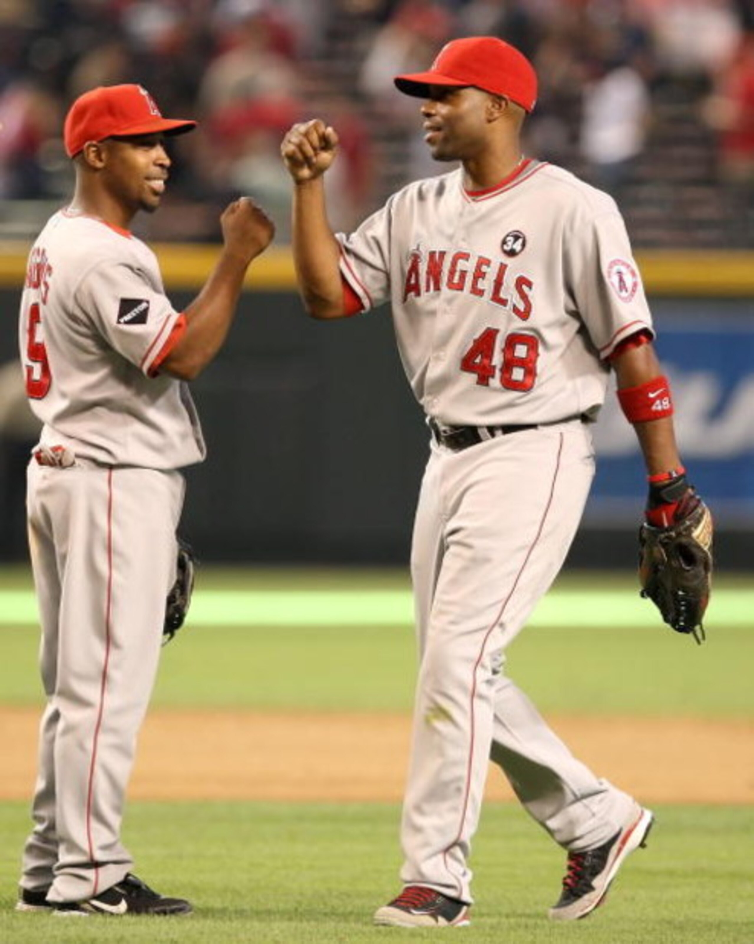 PHOENIX - JUNE 27:  Chone Figgins #9 and Torii Hunter #48 of the Los Angeles Angels of Anaheim celebrate after defeating the Arizona Diamondbacks during the major league baseball game at Chase Field on June 27, 2009 in Phoenix, Arizona. The Angels defeate